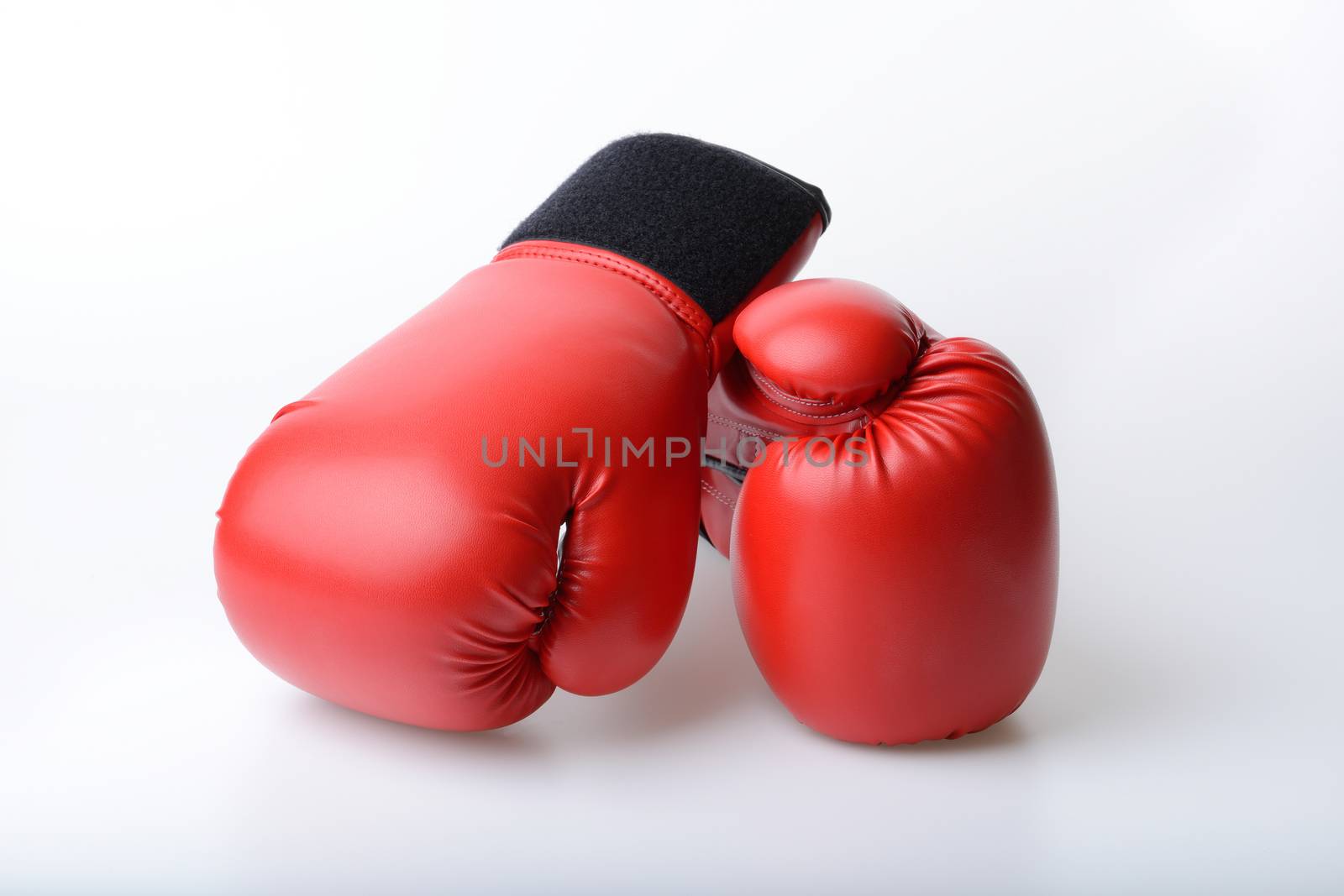 Pair of red leather boxing gloves on white background