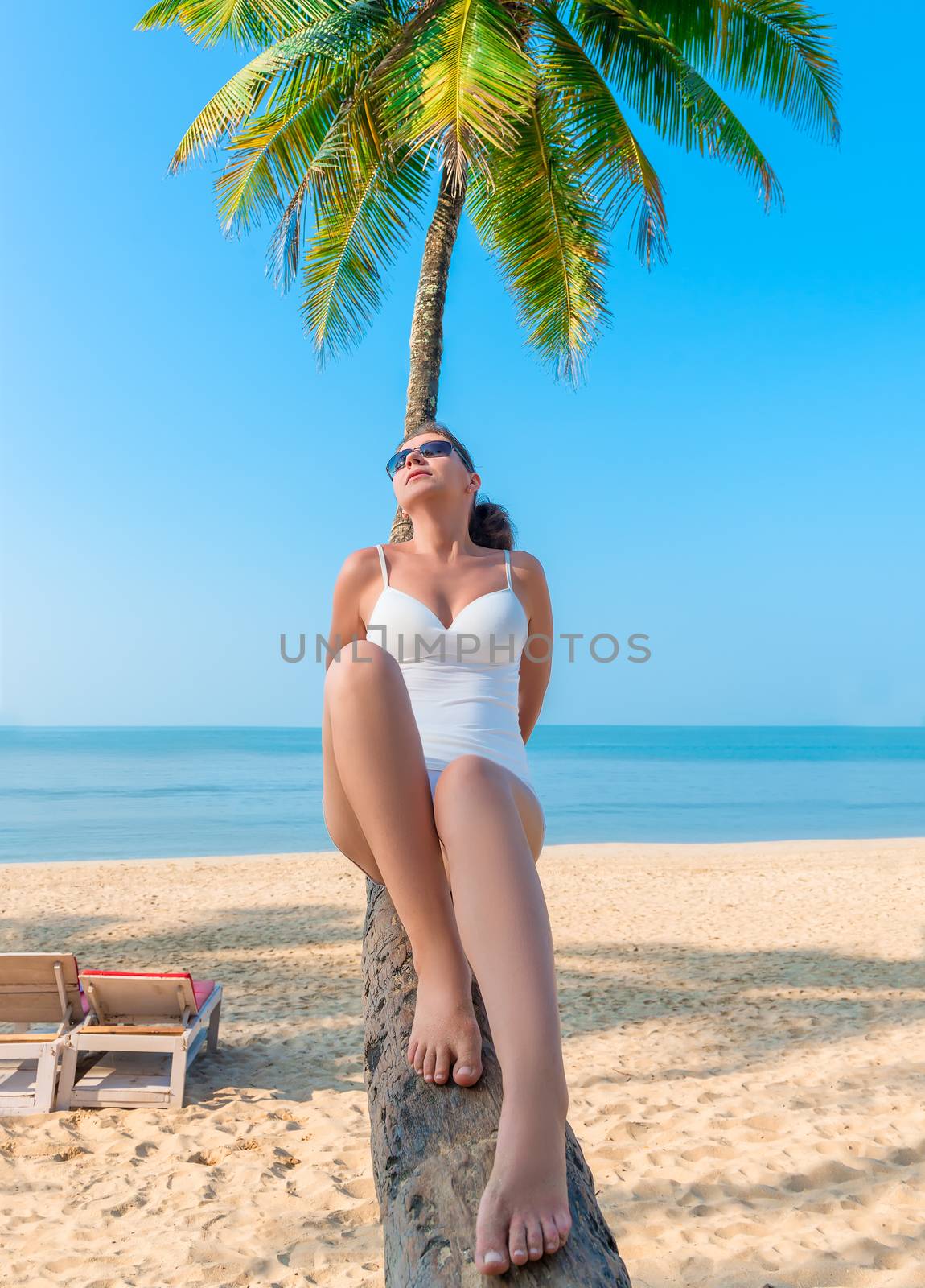 young beautiful girl relaxes on the beach in the tropics