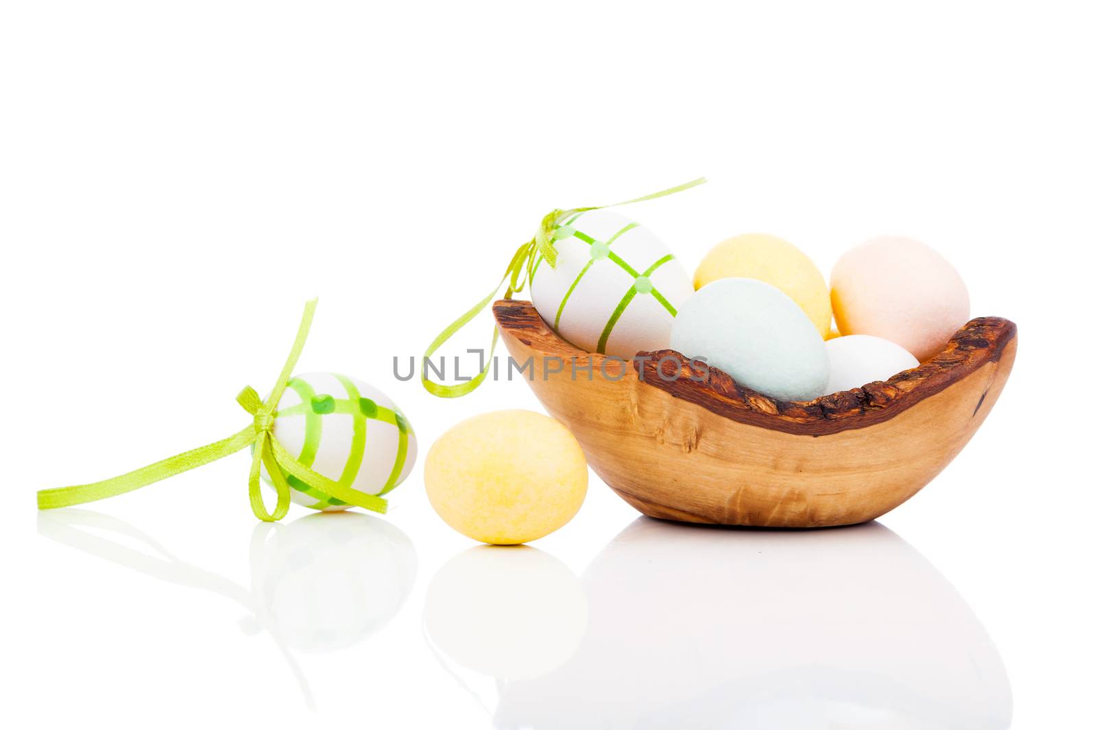 Easter eggs in wooden bowl, isolated on white background