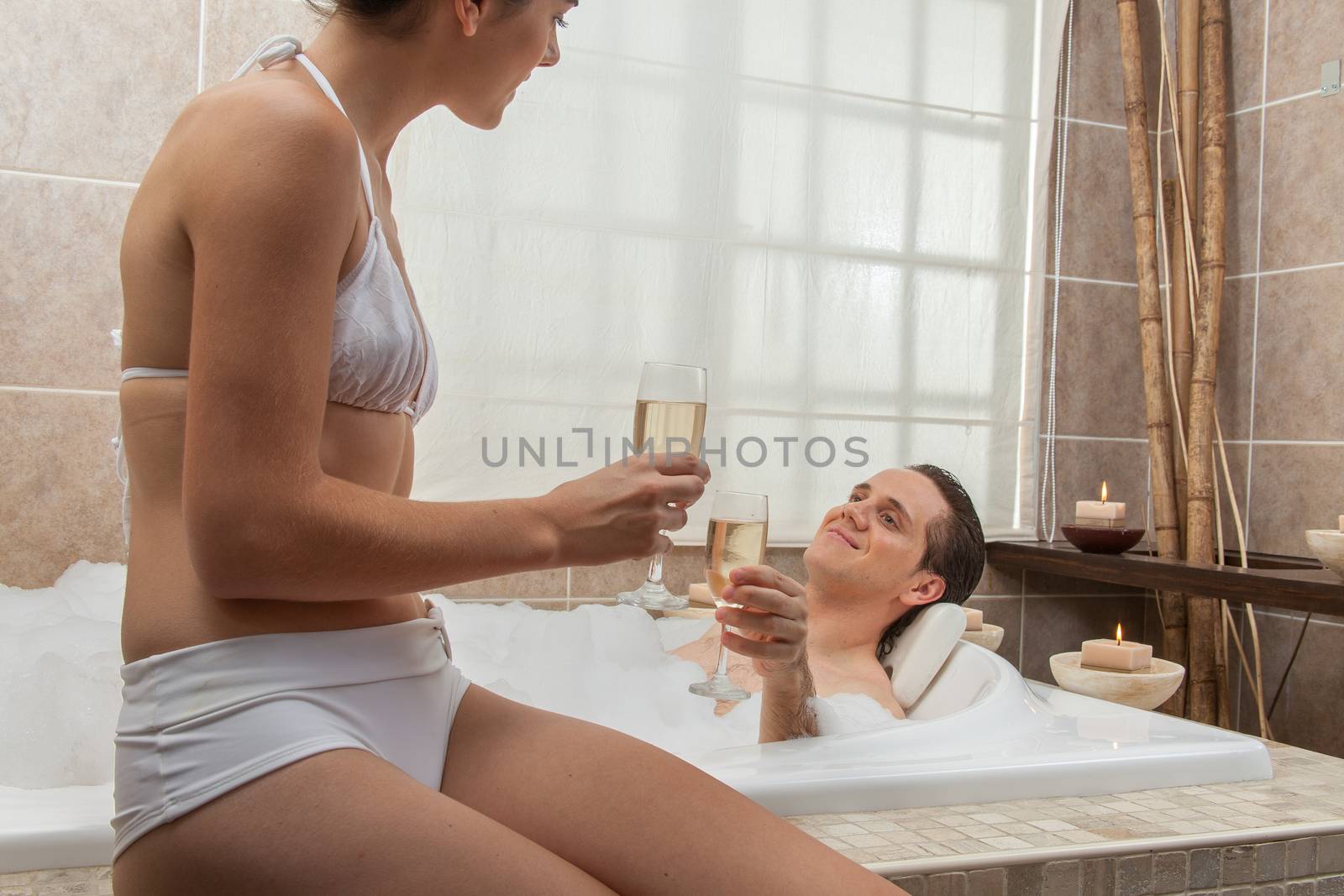 Couple in the tub drinking champagne