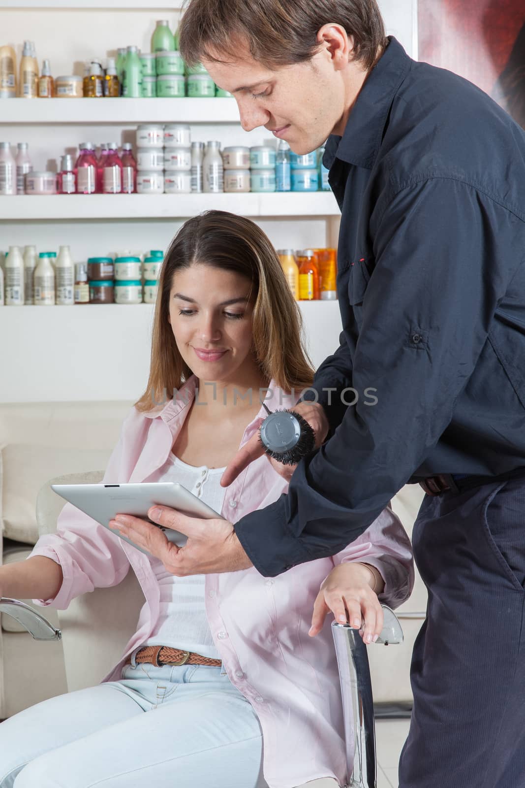 The hairstylist showing to one woman the ipad