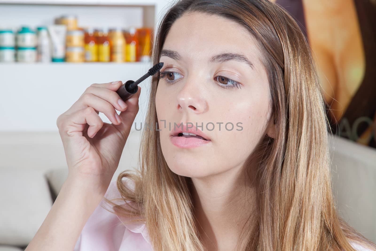 Serious woman putting on mascara