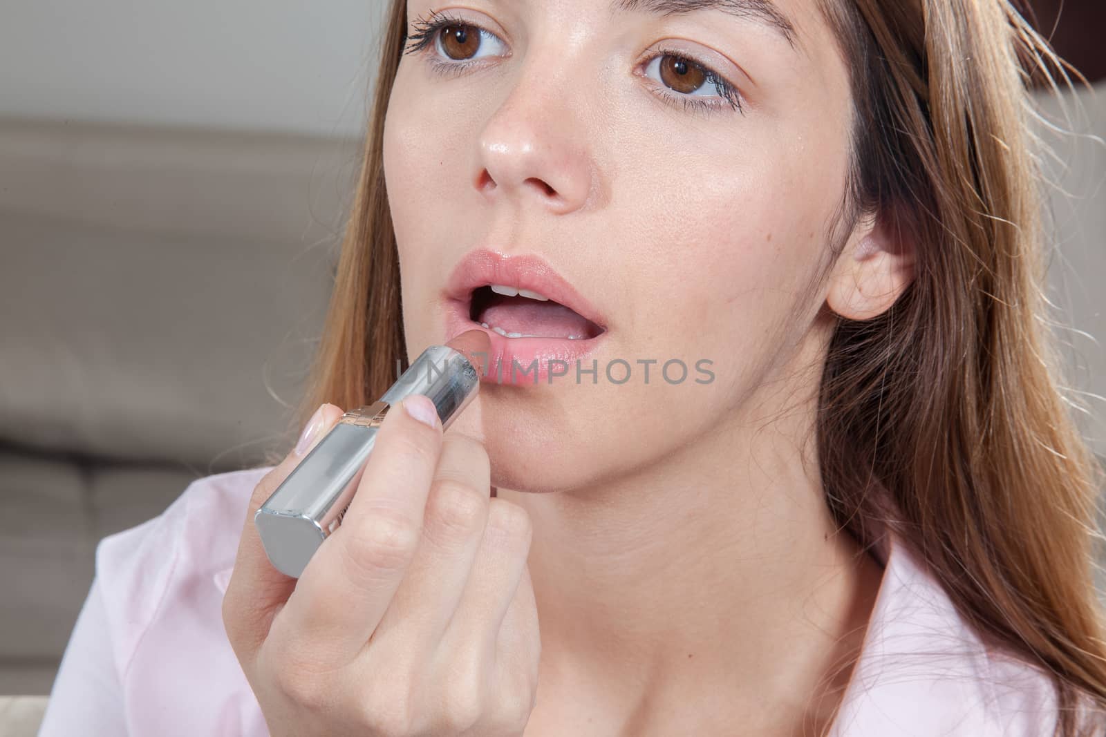 Pretty woman putting her lipstick