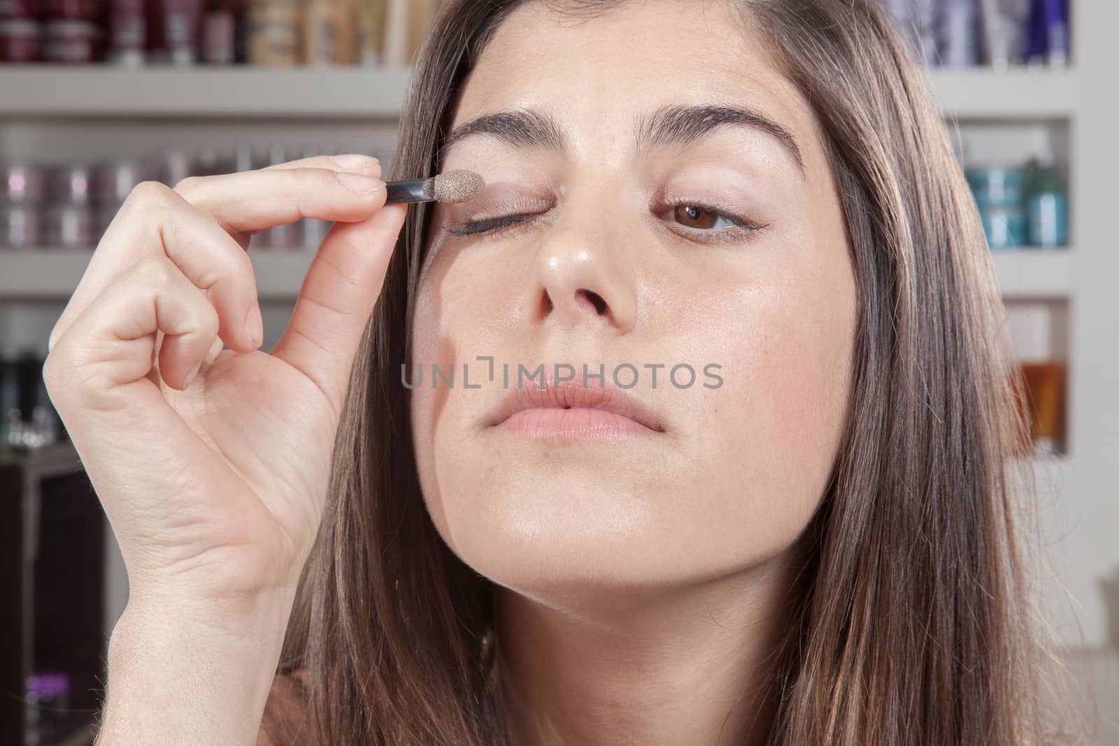 Concentrated woman applying eye shadow itself