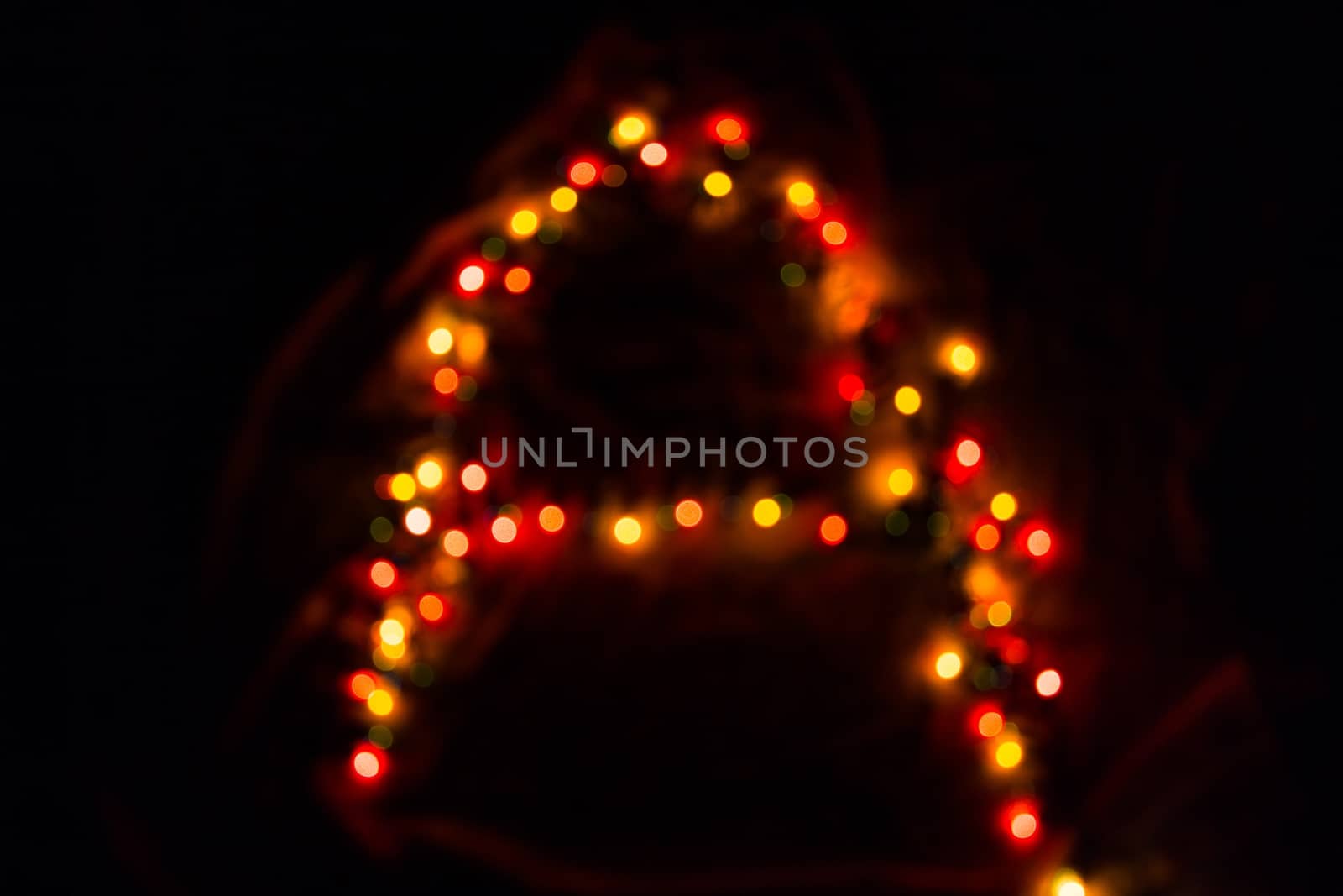 colorful letter A made of blurred circular bokeh on black background