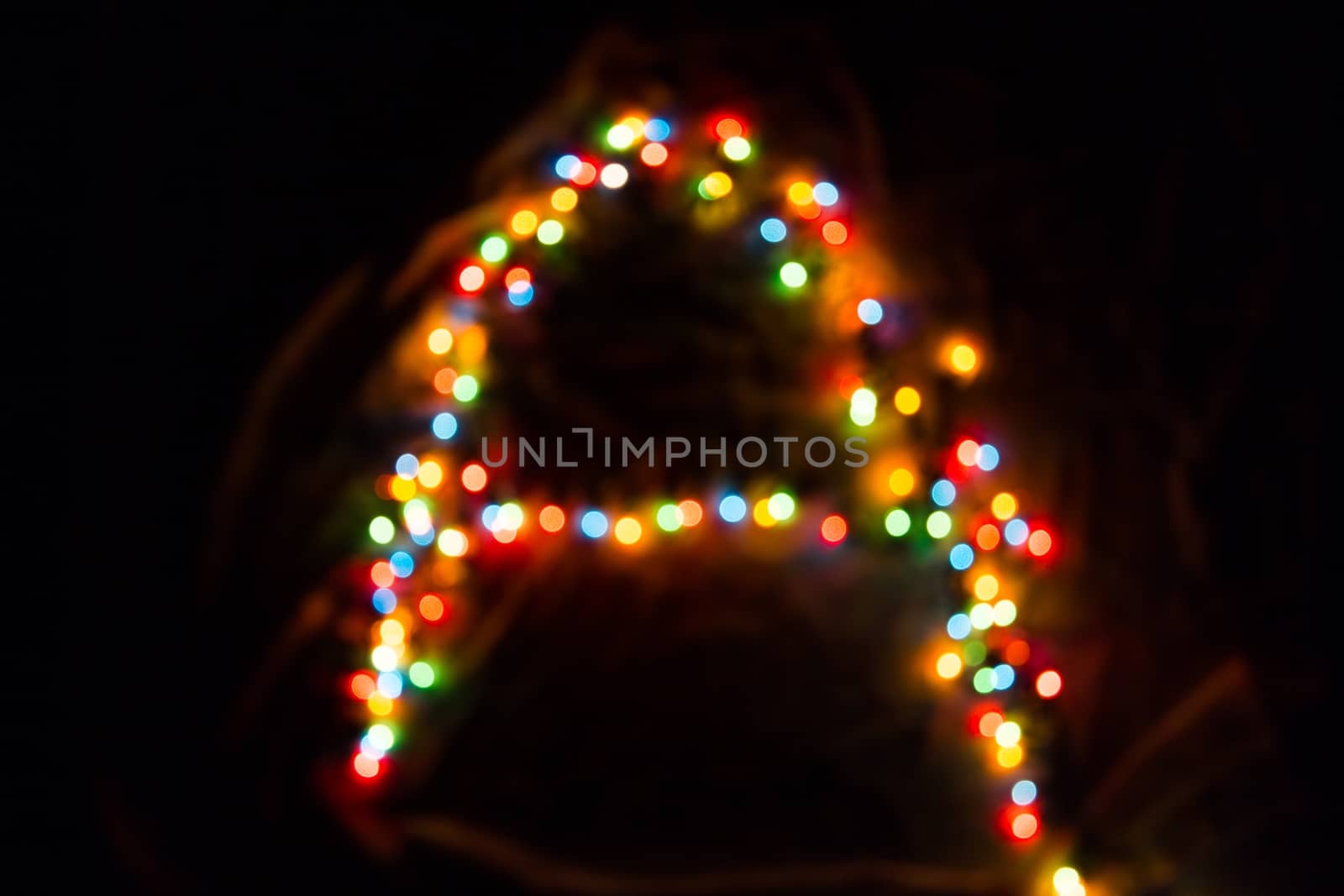 colorful letter A made of blurred circular bokeh on black background