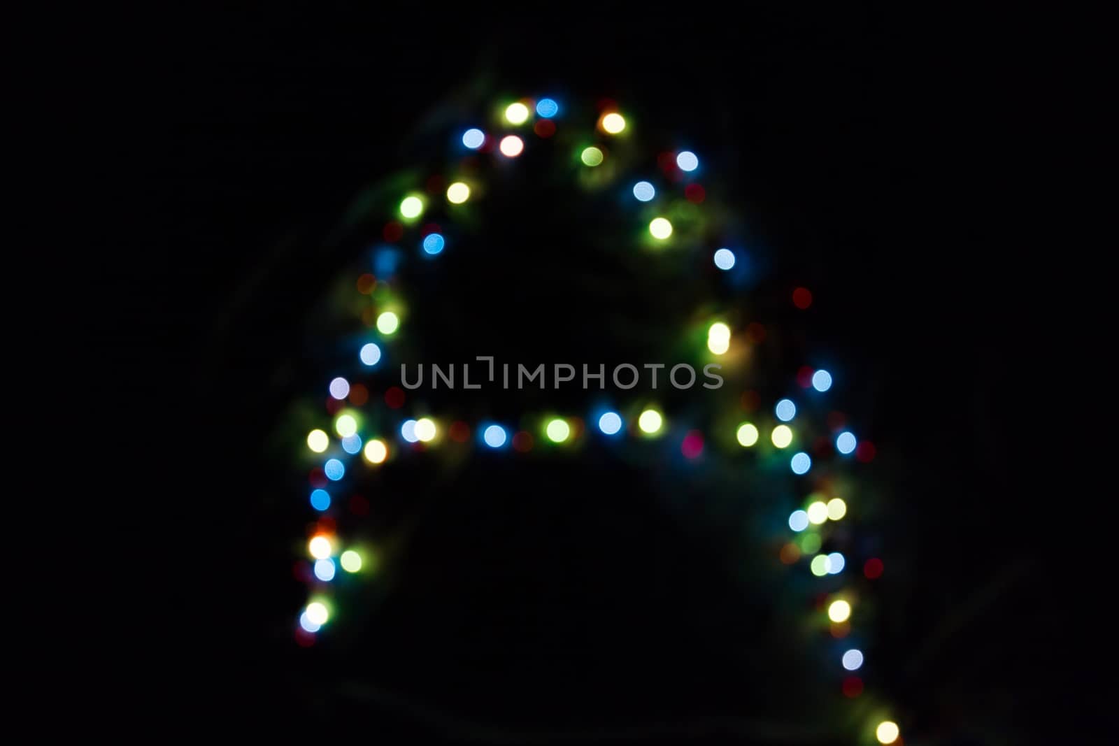 colorful letter A made of blurred circular bokeh on black background