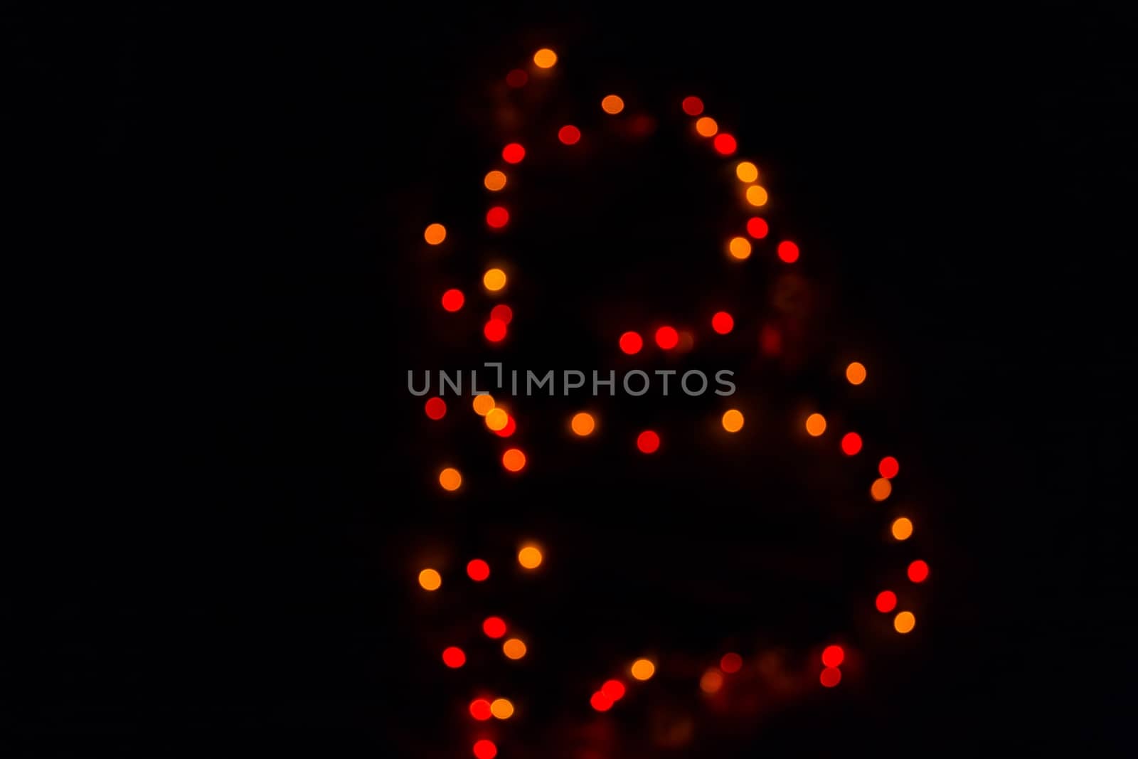 colorful letter B made of blurred circular bokeh on black background