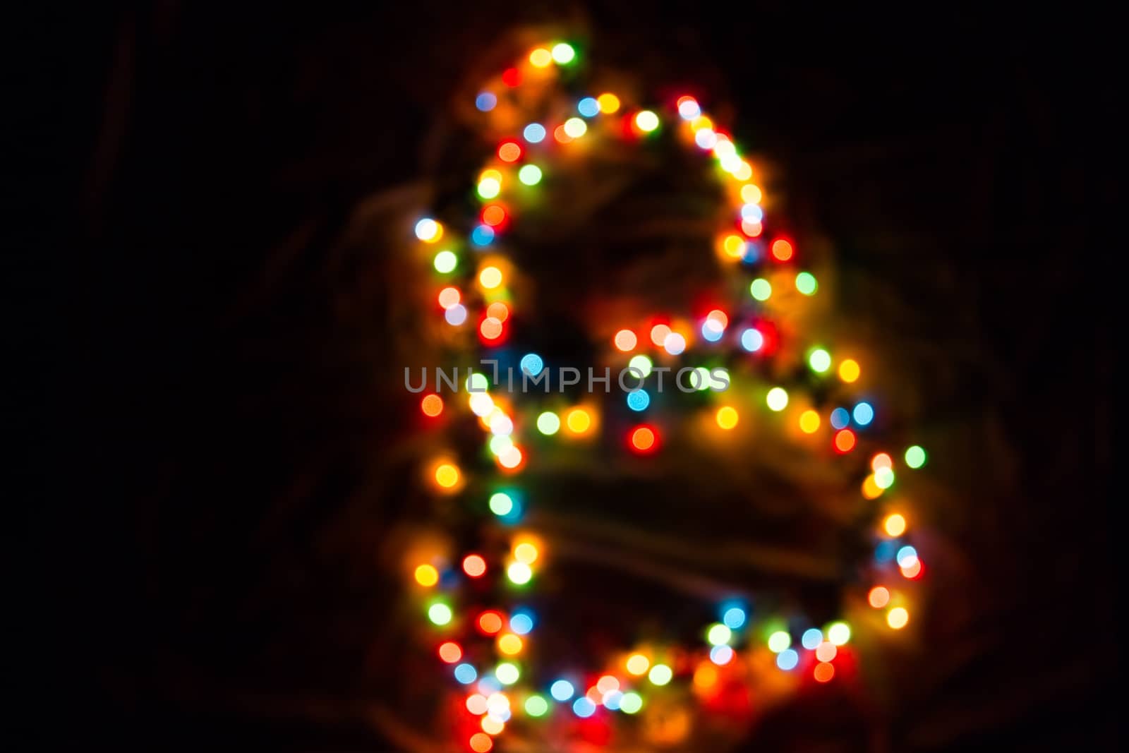 colorful letter B made of blurred circular bokeh on black background