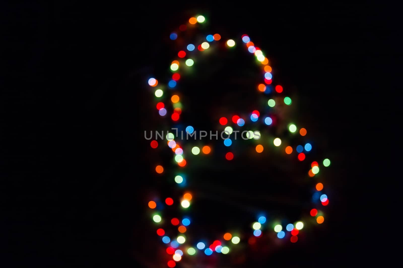 colorful letter B made of blurred circular bokeh on black background