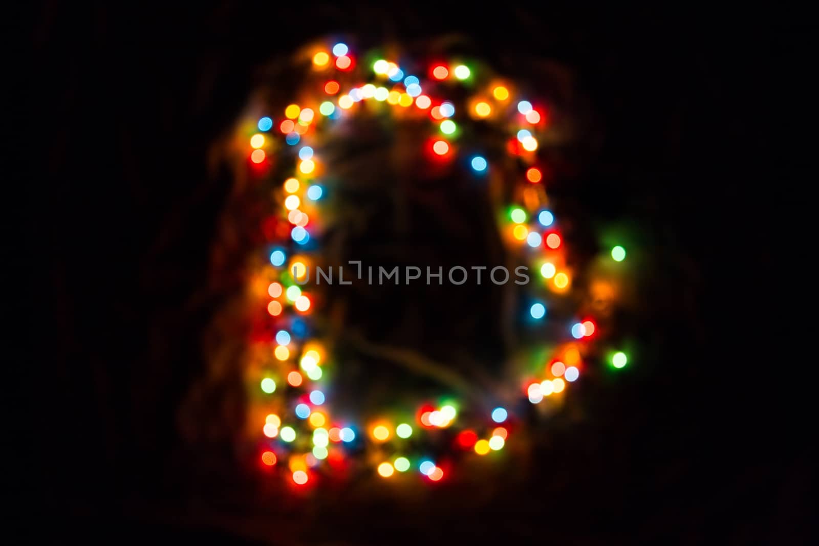 colorful letter D made of blurred circular bokeh on black background