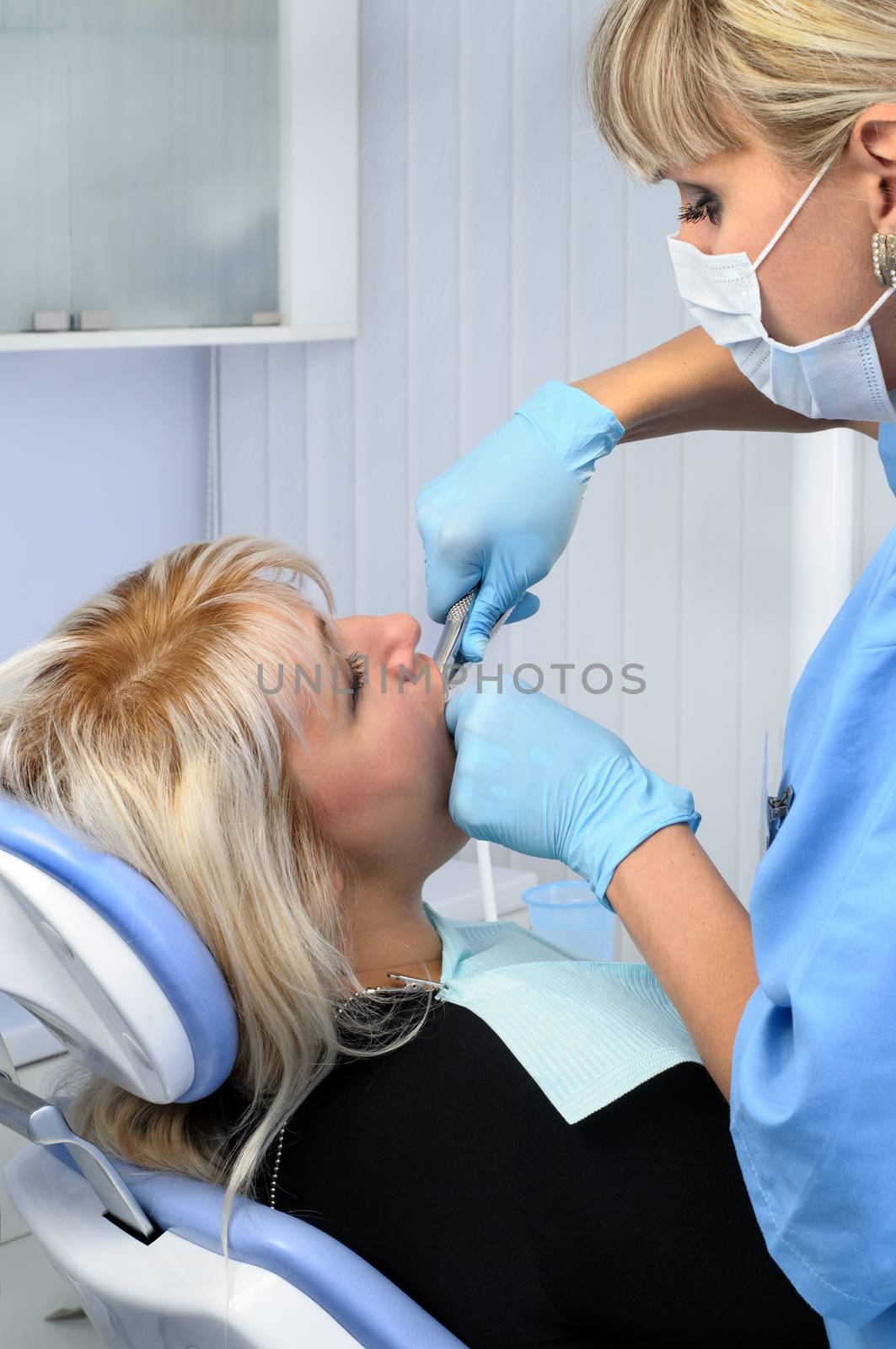 Dentist at work, tooth extraction using forceps