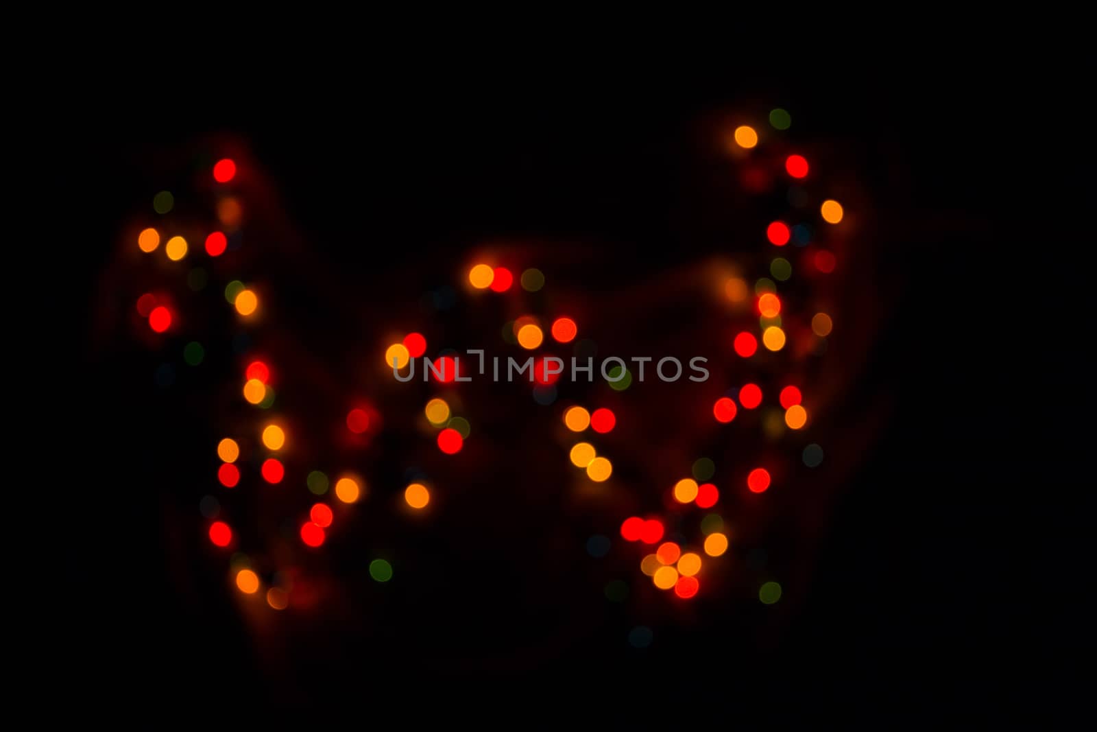 defocused colorful letter W made of blurred circular bokeh on black background