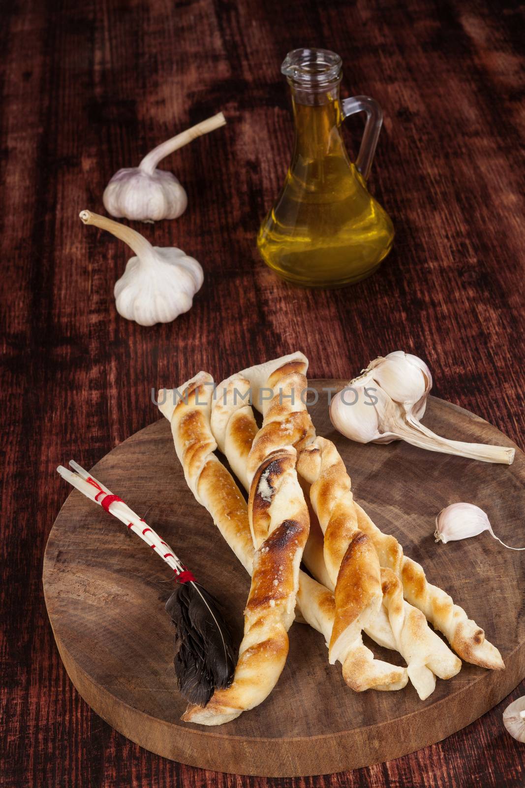 Pizza bread on round kitchen board on wooden kitchen table. Traditional pizza background. 