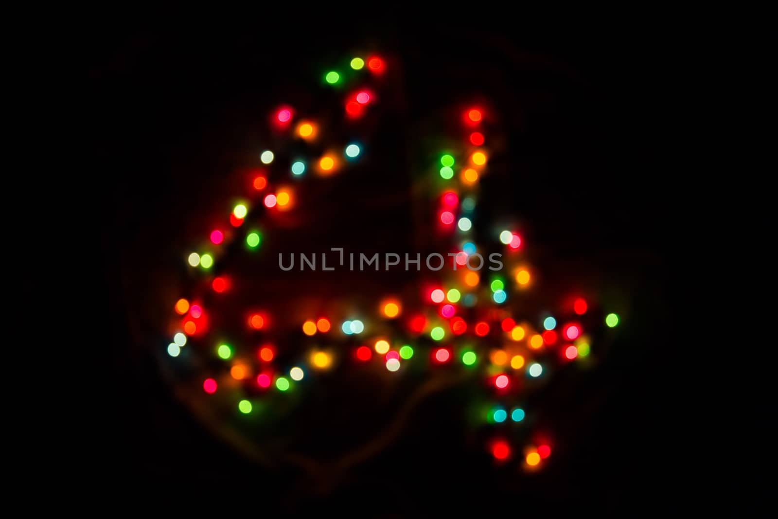 defocused colorful number four made of blurred circular bokeh on black background