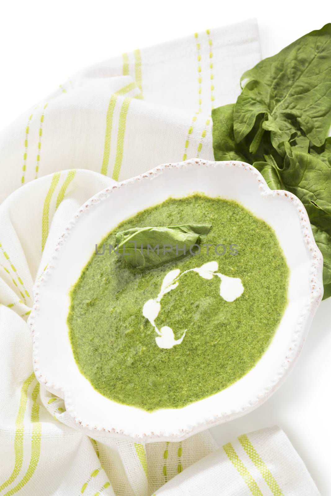 Delicious spinach soup with fresh spinach leaves isolated on white background. Healthy soup eating.