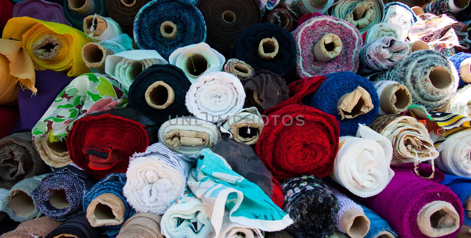 fabric of different colors in rolls in stock shop