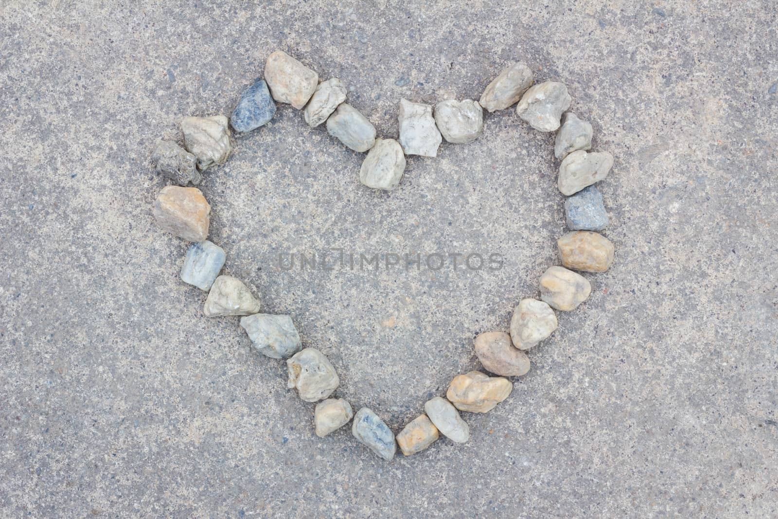 Heart made of stones on concrete background