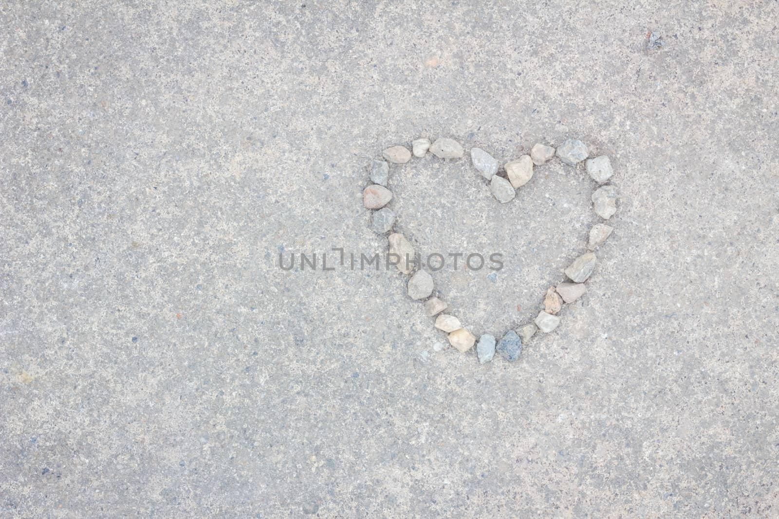 Heart made of stones on concrete background, with copyspace