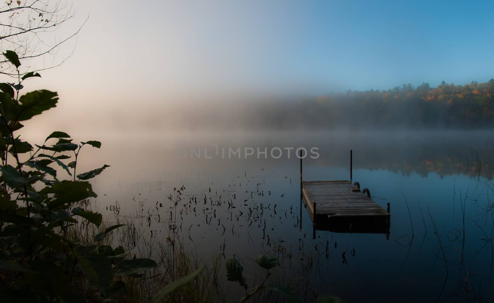 Early morning sunrise burns off the fog which has lingered over the lake.