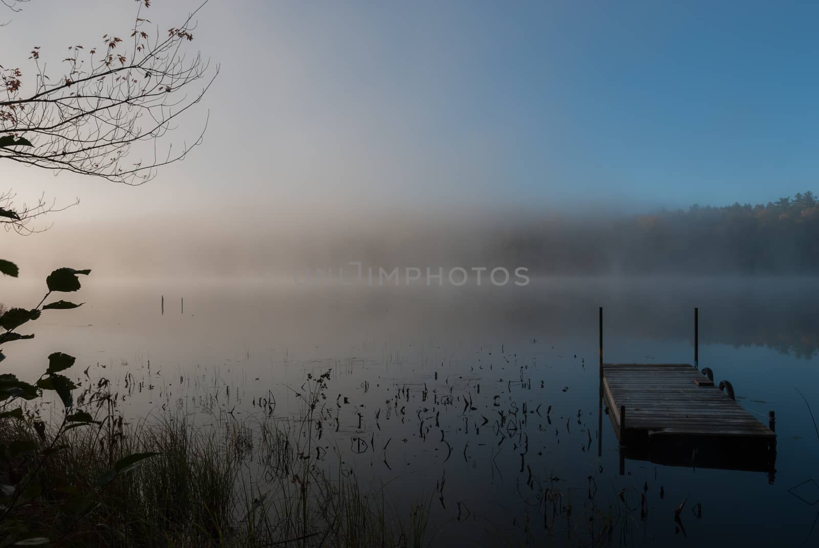 Early morning sunrise burns off the fog which has lingered over the lake.