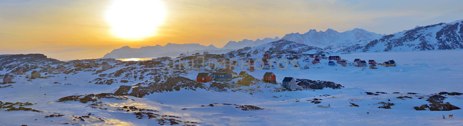 Winter landscape with colorful houses in Kulusuk, Greenland, at sunset
