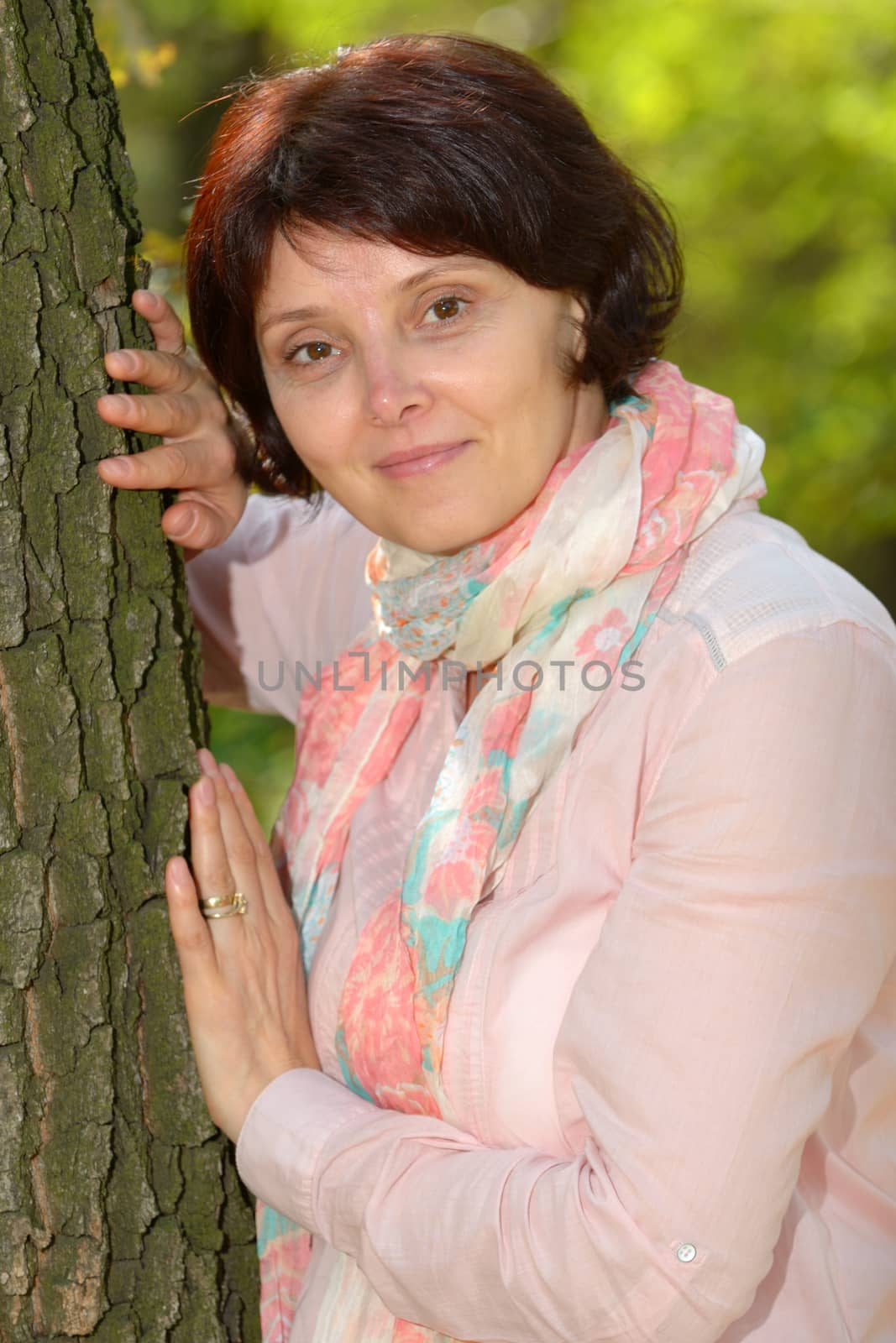 portrait of woman leaning against tree