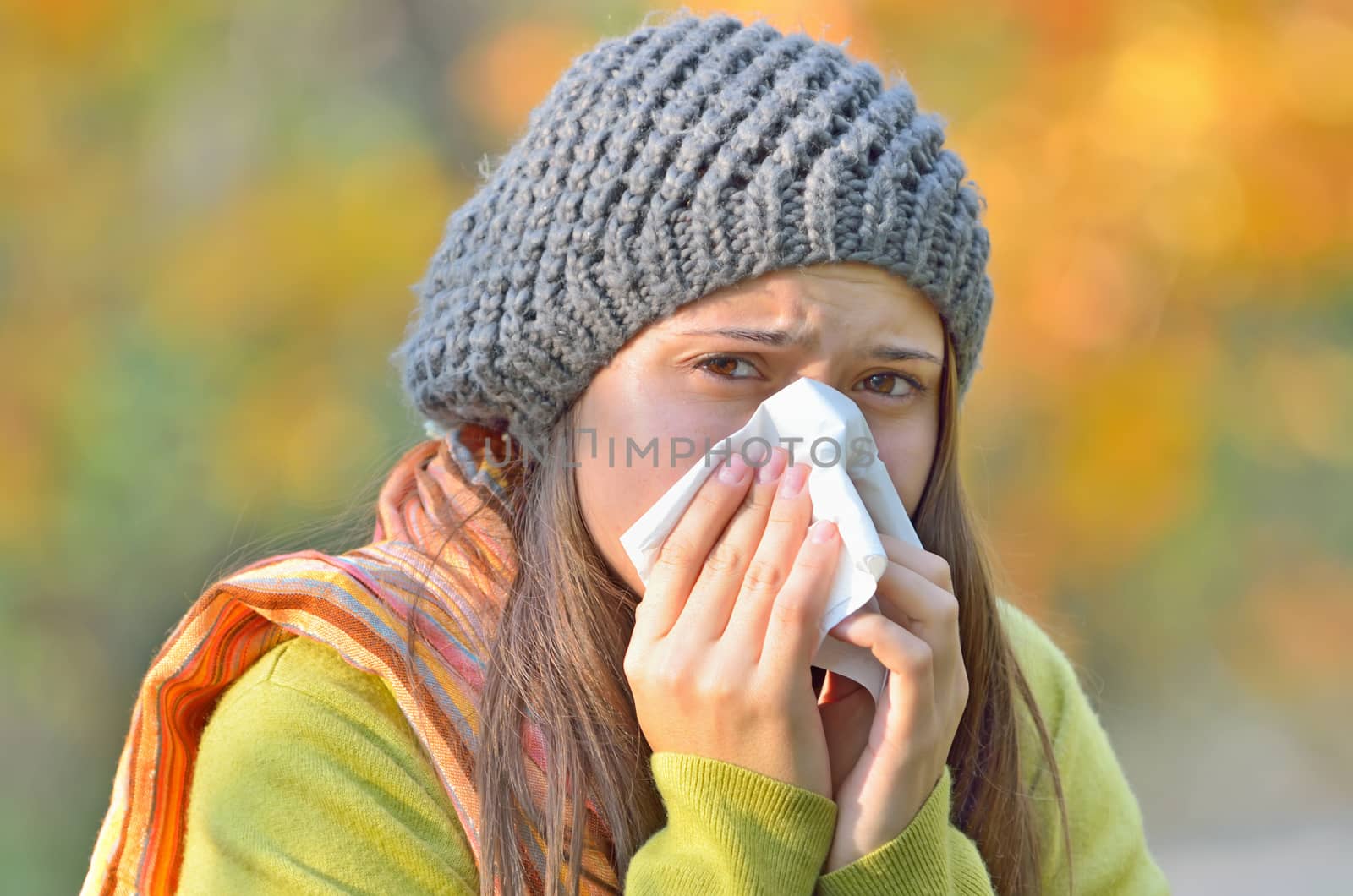 girl blowing nose in autumn background