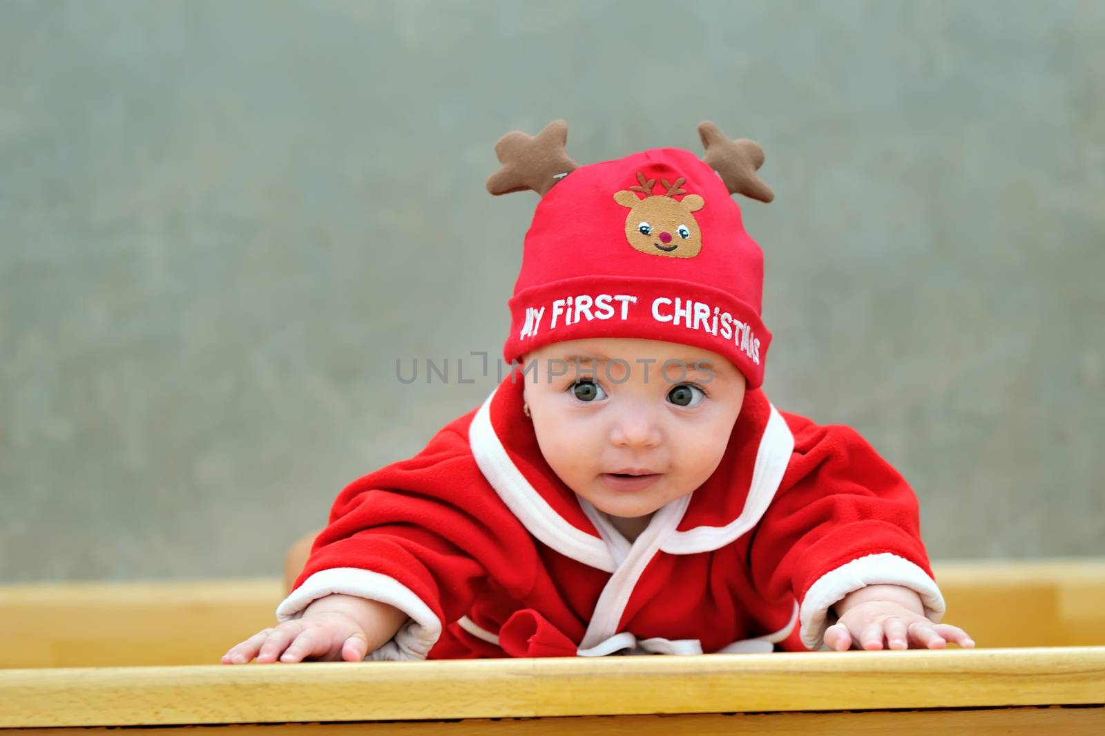 little baby  in red winter reindeer hat,  looking in front