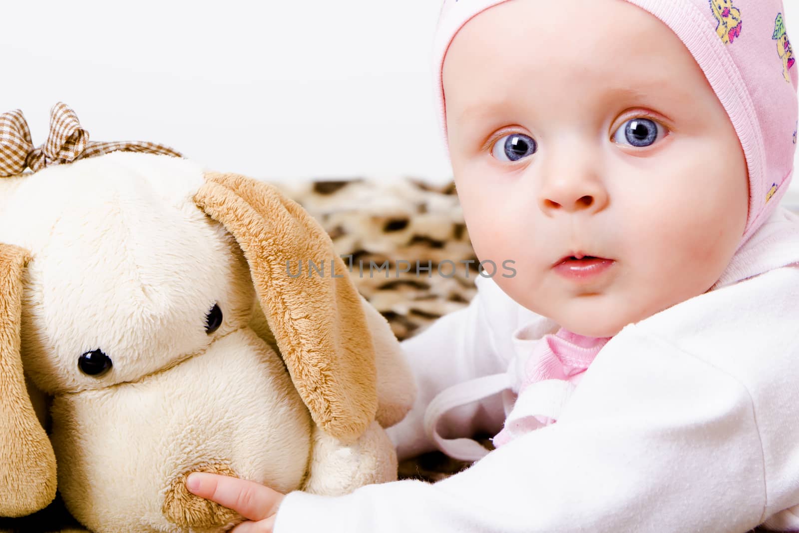 blue-eyed baby with a soft toy. studio photo. wonder