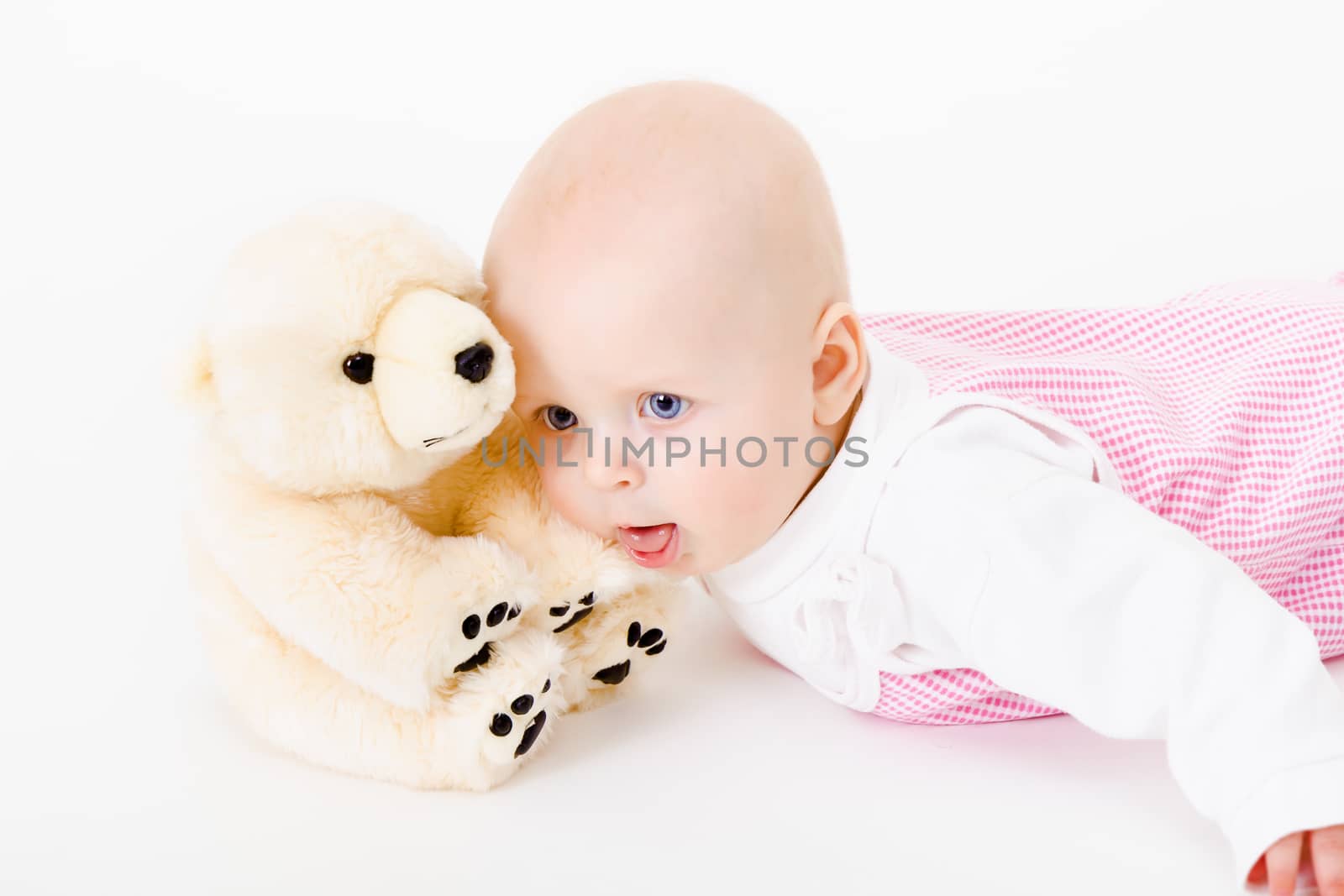 blue-eyed baby with a soft toy. studio photo. nausea. humor