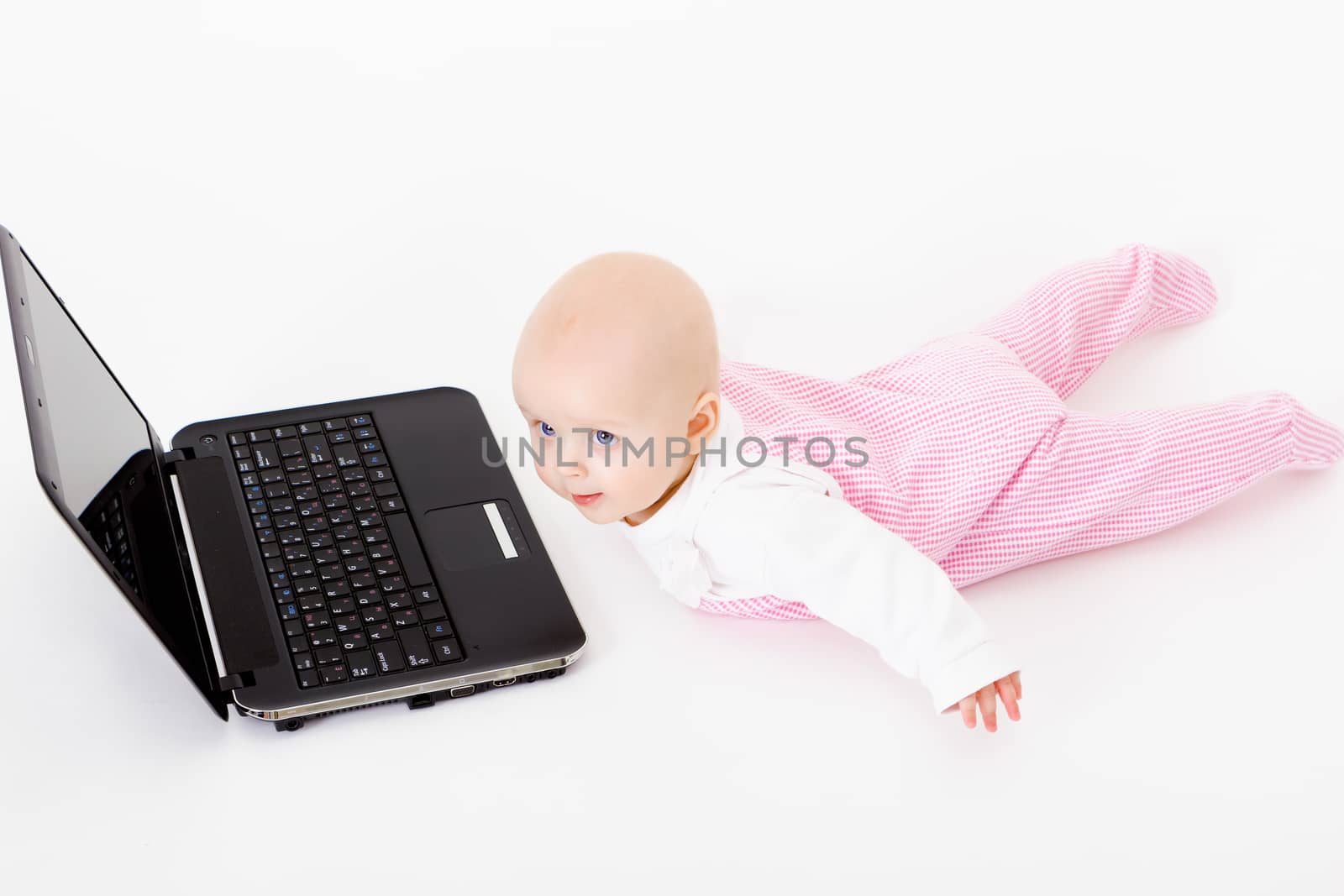 wearing a rompers baby with laptop. studio photo