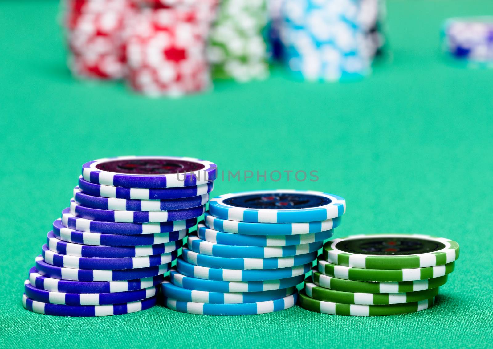 stack of chips on a green table casino