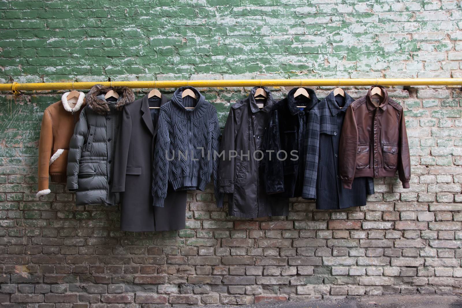 Men's trendy clothing on grunge brick wall. Concept background
