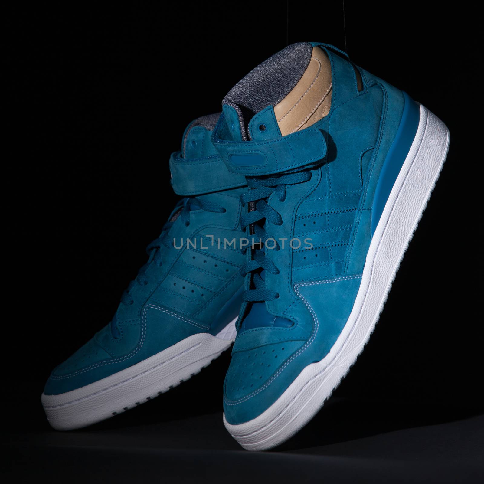 Picture of a pair of blue trainers over a black background