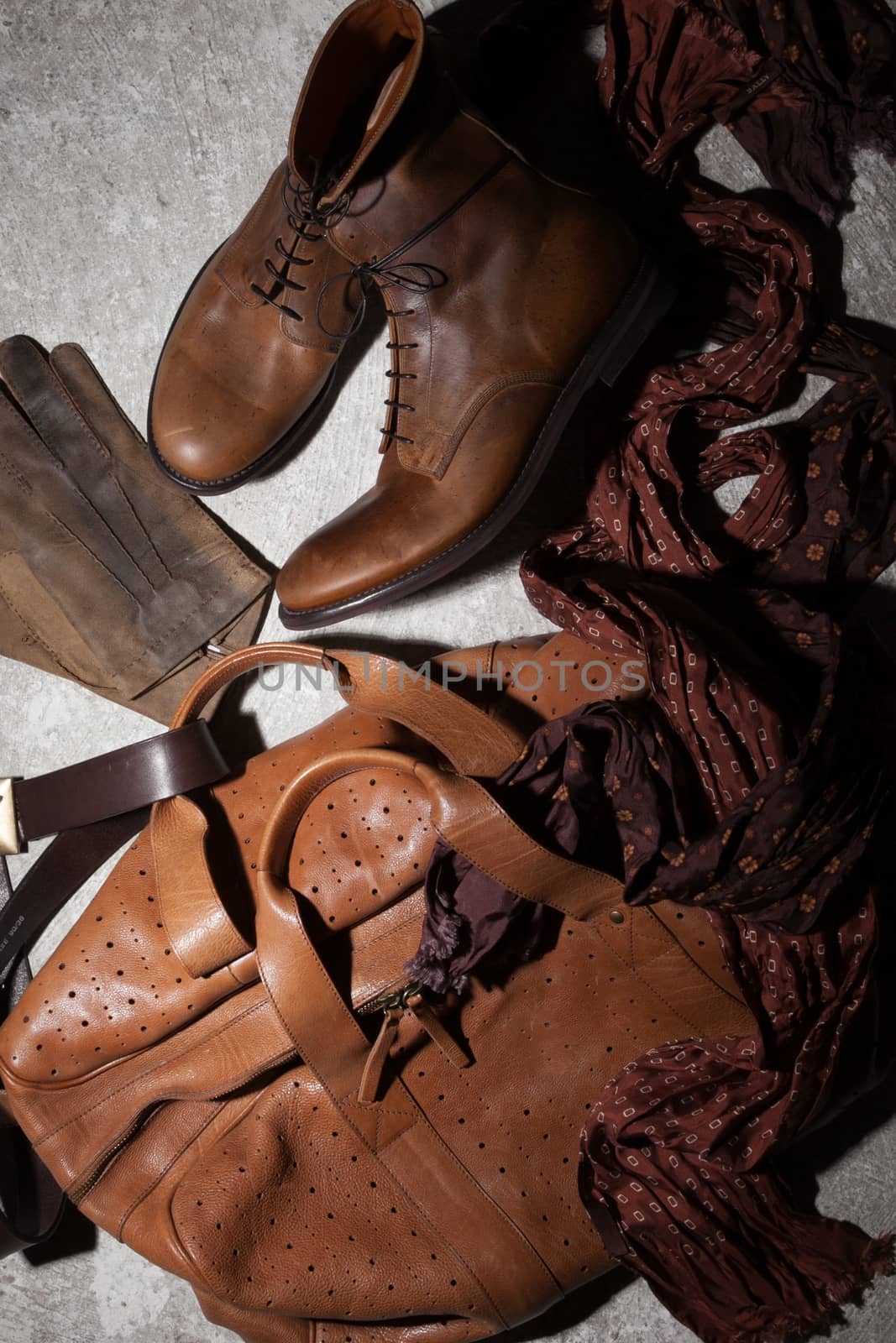 Brown leather bag and accessories on a dark background