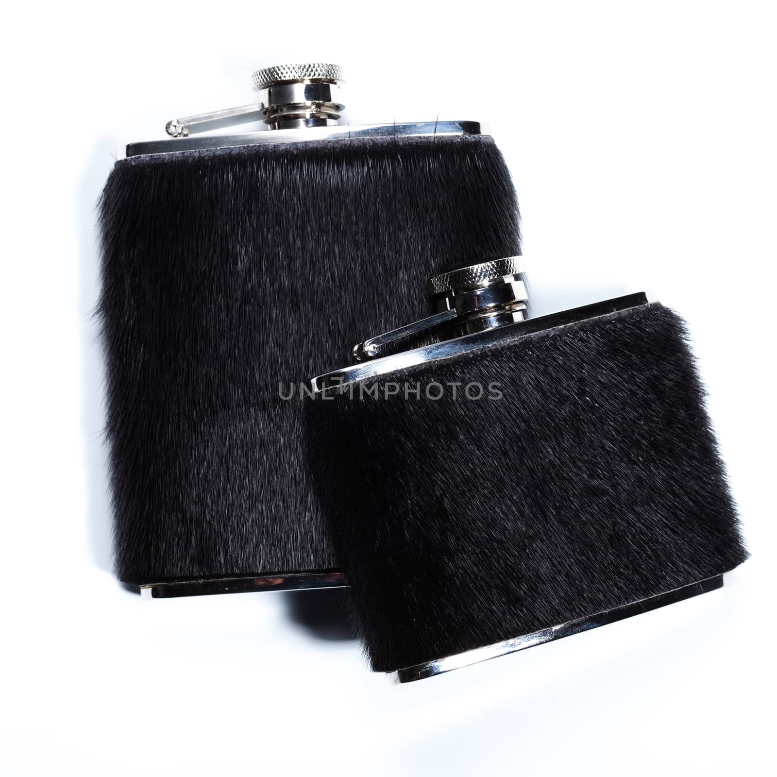 Pair metal flasks with black fur for alcoholic beverages on white.