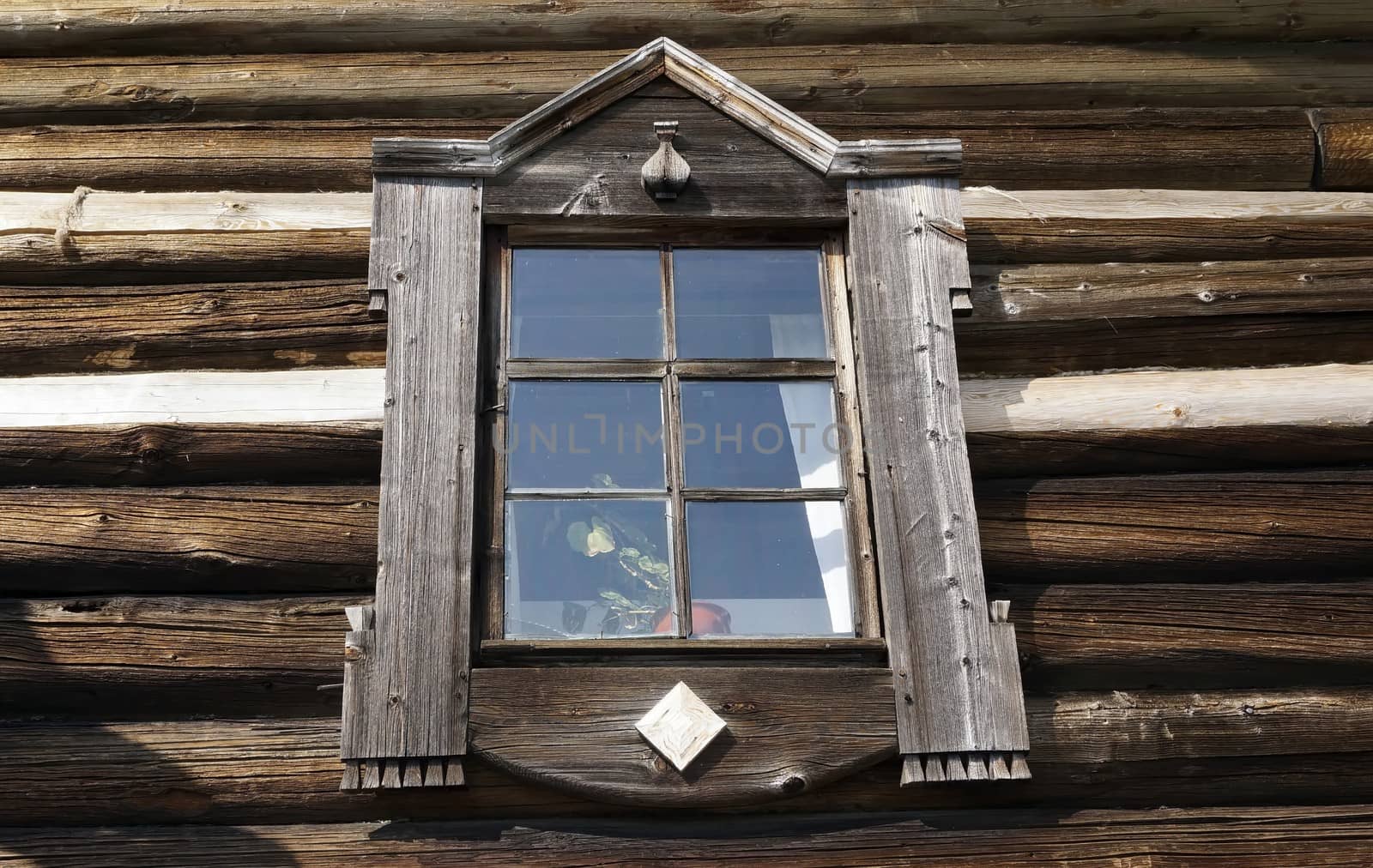 Old window on the wall of a wooden house. by mcherevan