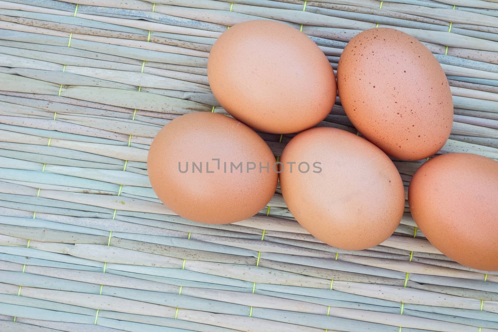 Close up of five eggs on thai traditional mat for cook, with copyspace