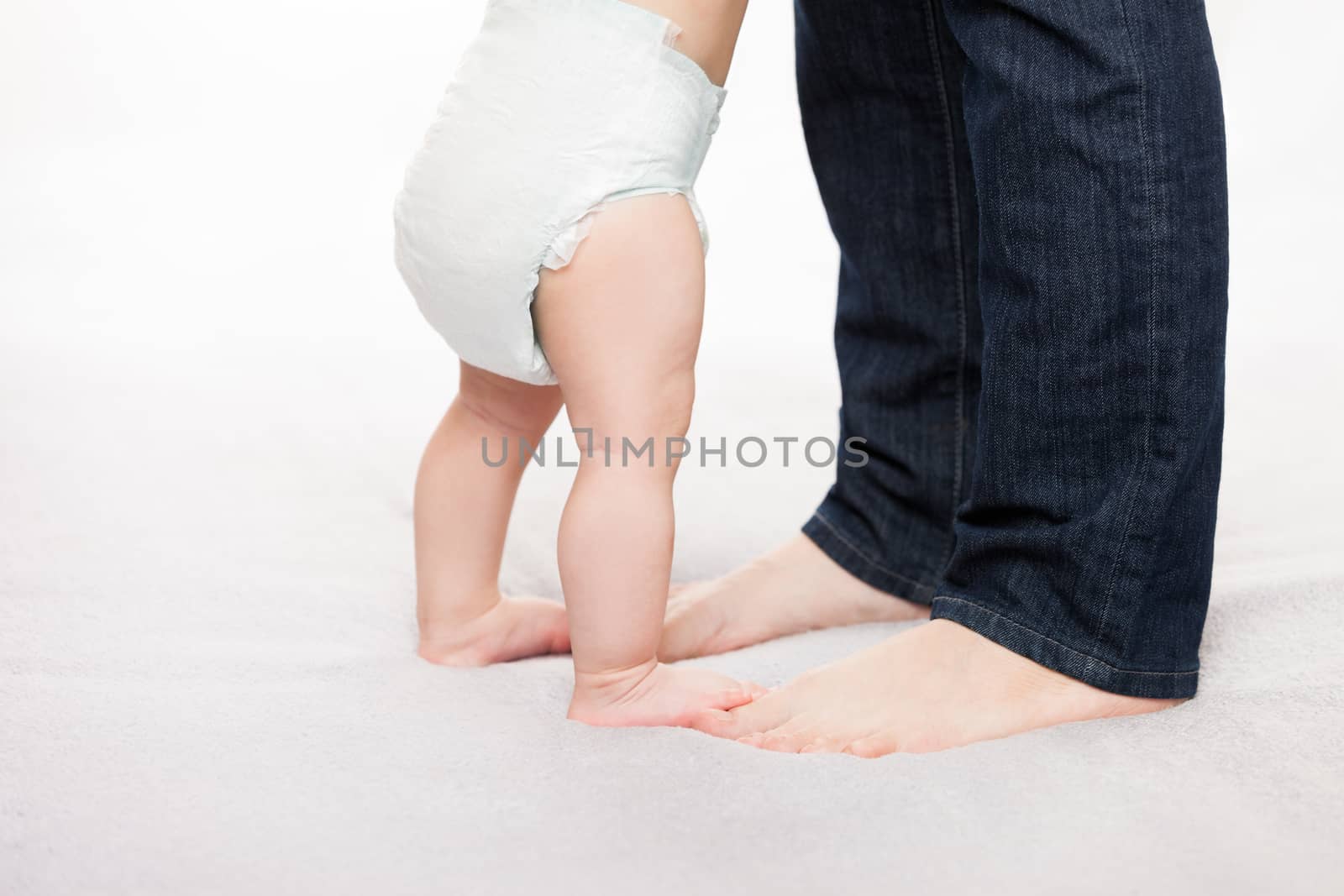 Walking toddler concept - little baby child boy making first step holding mother 