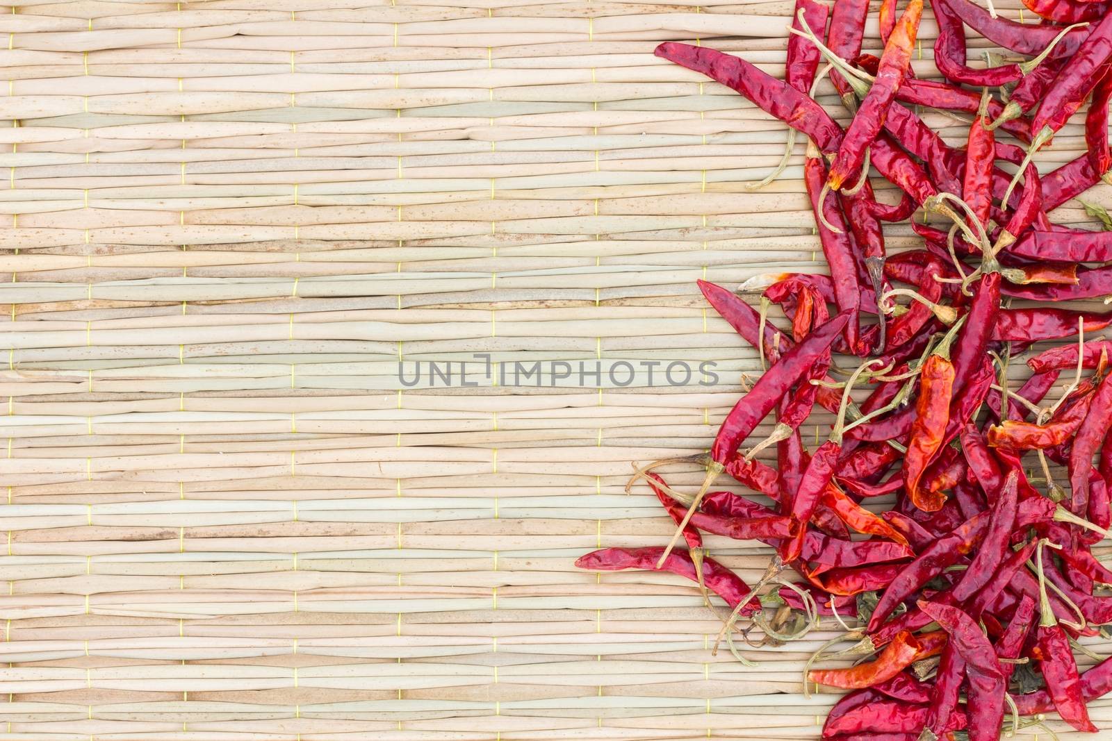 Dried red hot peppers on traditional mat, with copyspace on the left