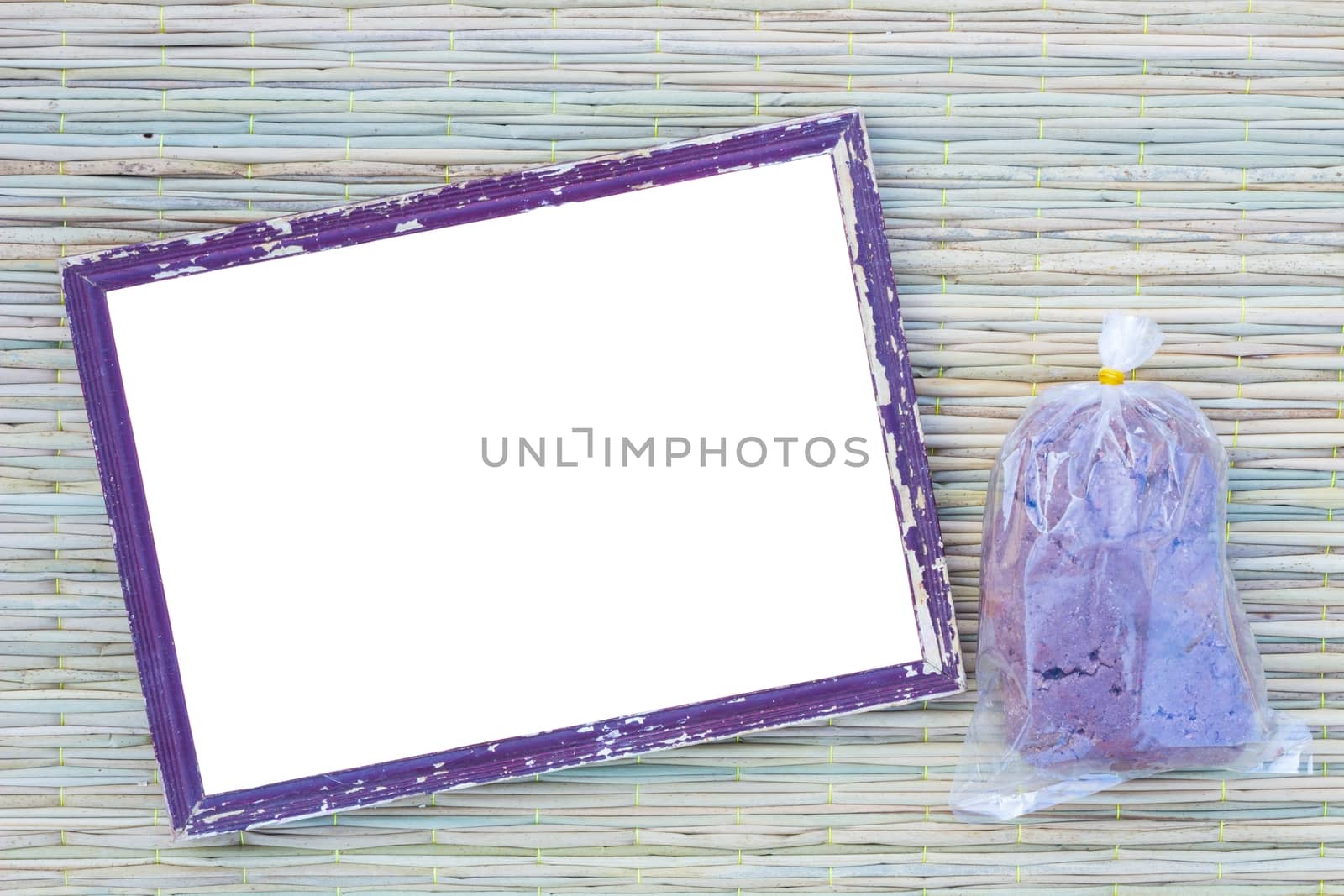 wooden old black picture frame on traditional mat with white space in the middle with shrimp paste in plastic bag