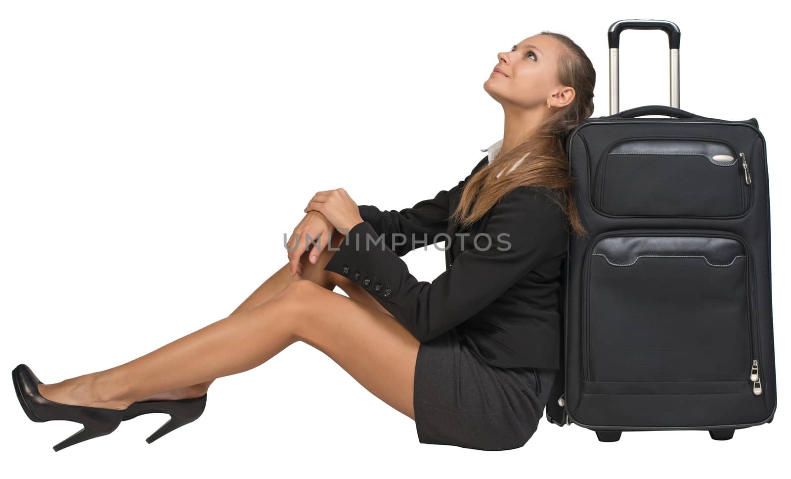 Businesswoman sitting next to front view suitcase with extended handle, looking upwards. Isolated over white background