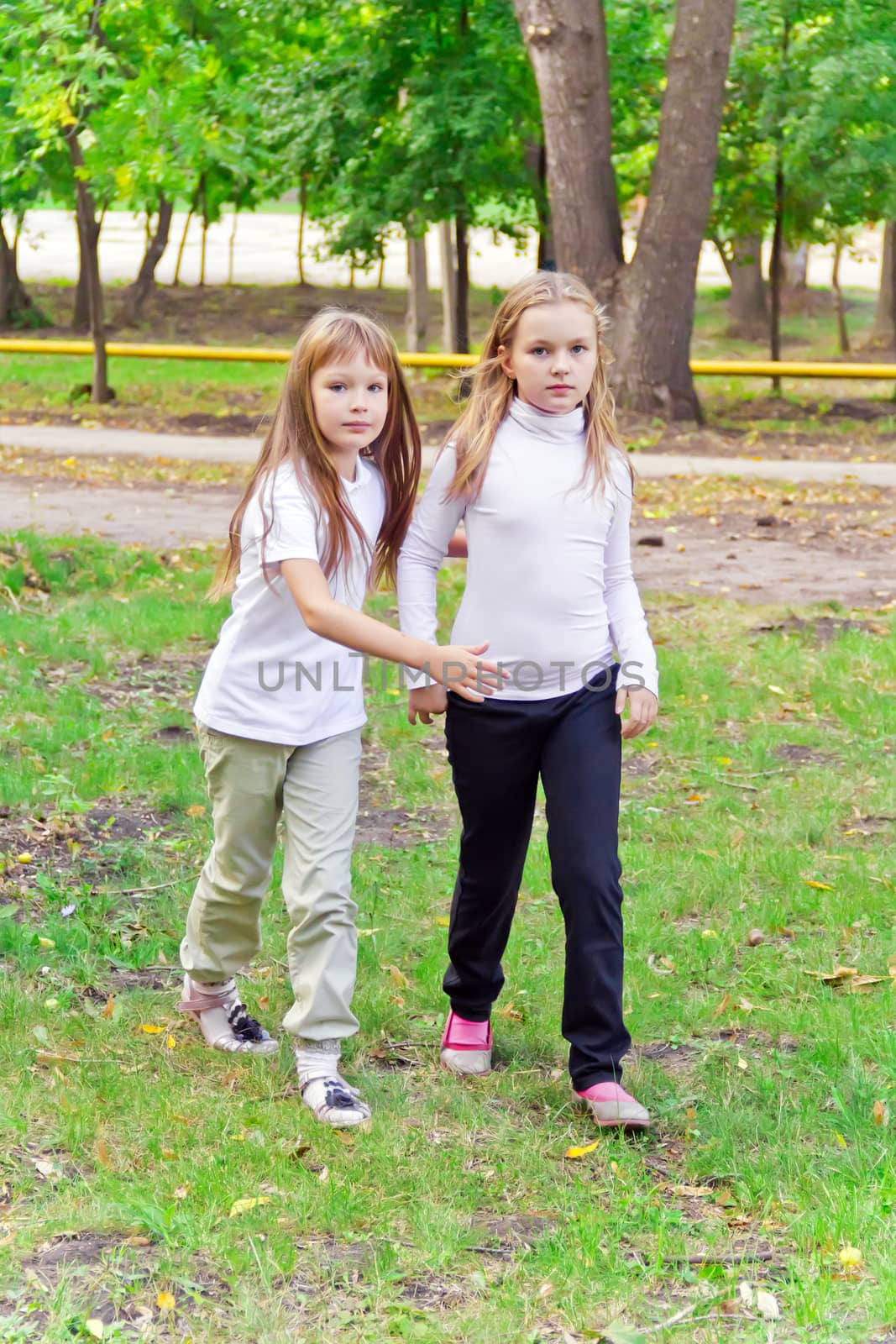 Photo of two walking girls in summer