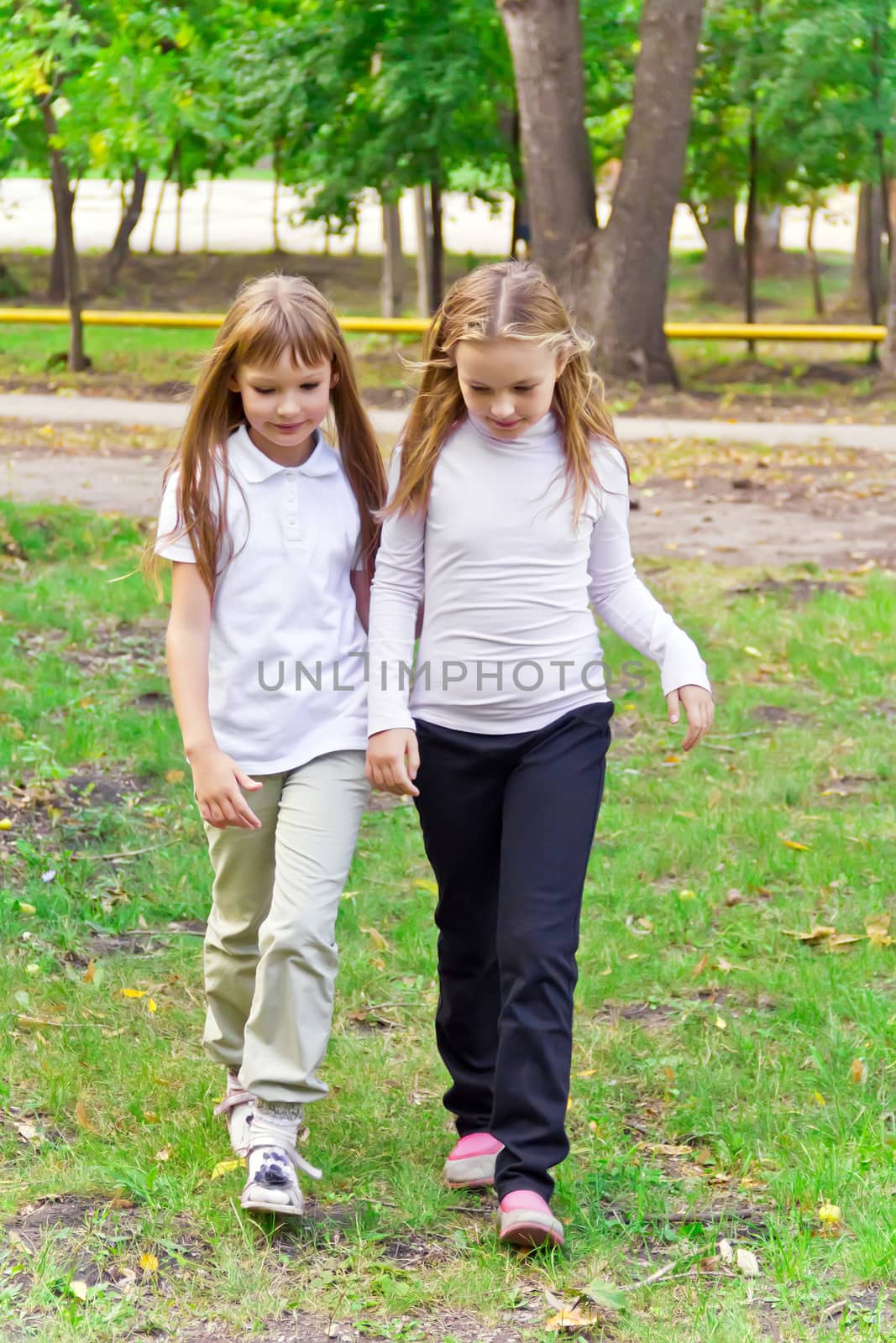 Photo of two walking girls in summer