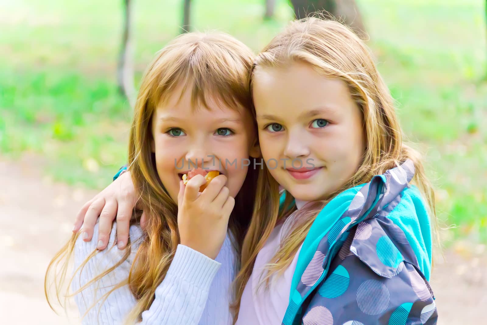 Photo of two eating girls in summer