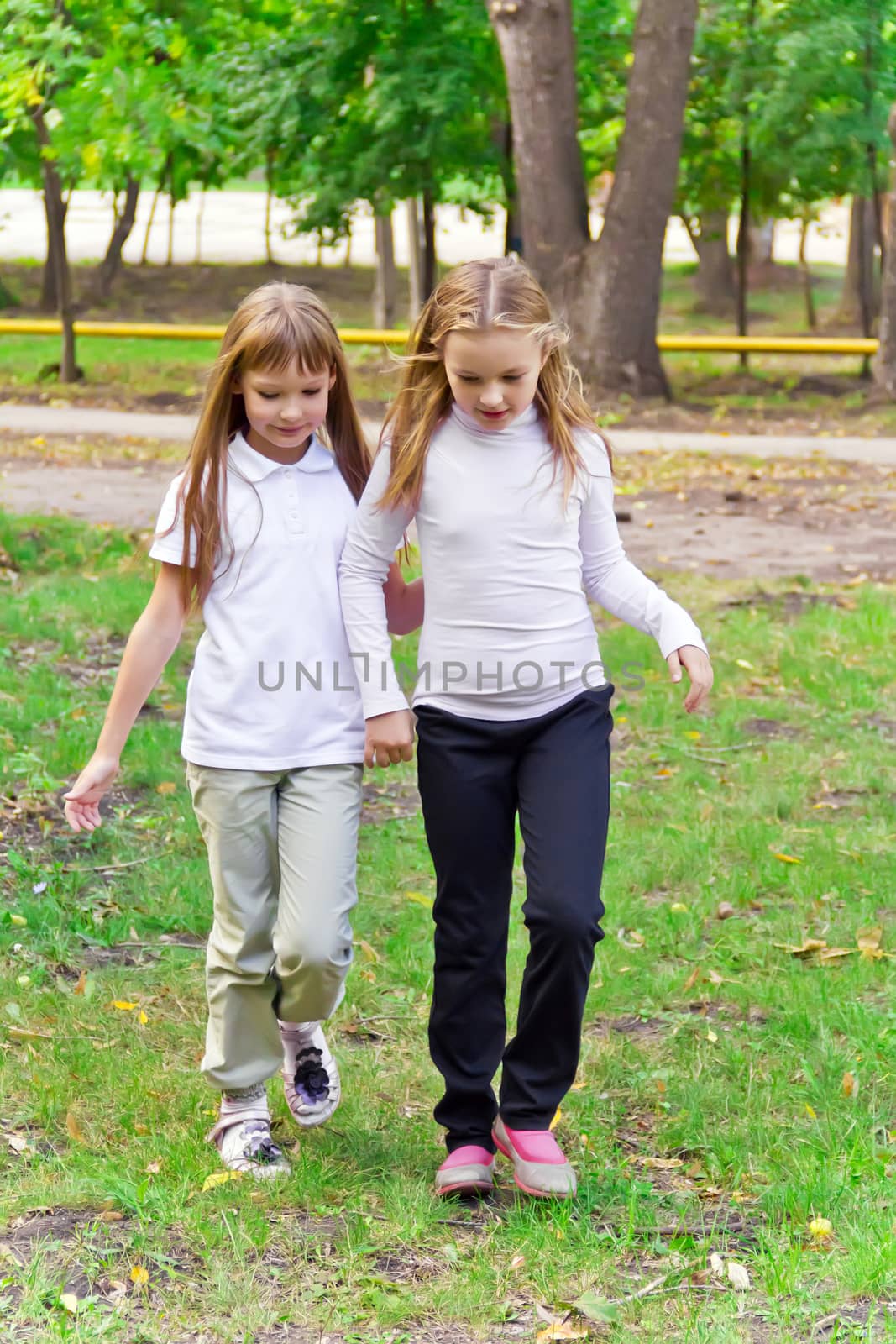 Photo of two walking girls in summer
