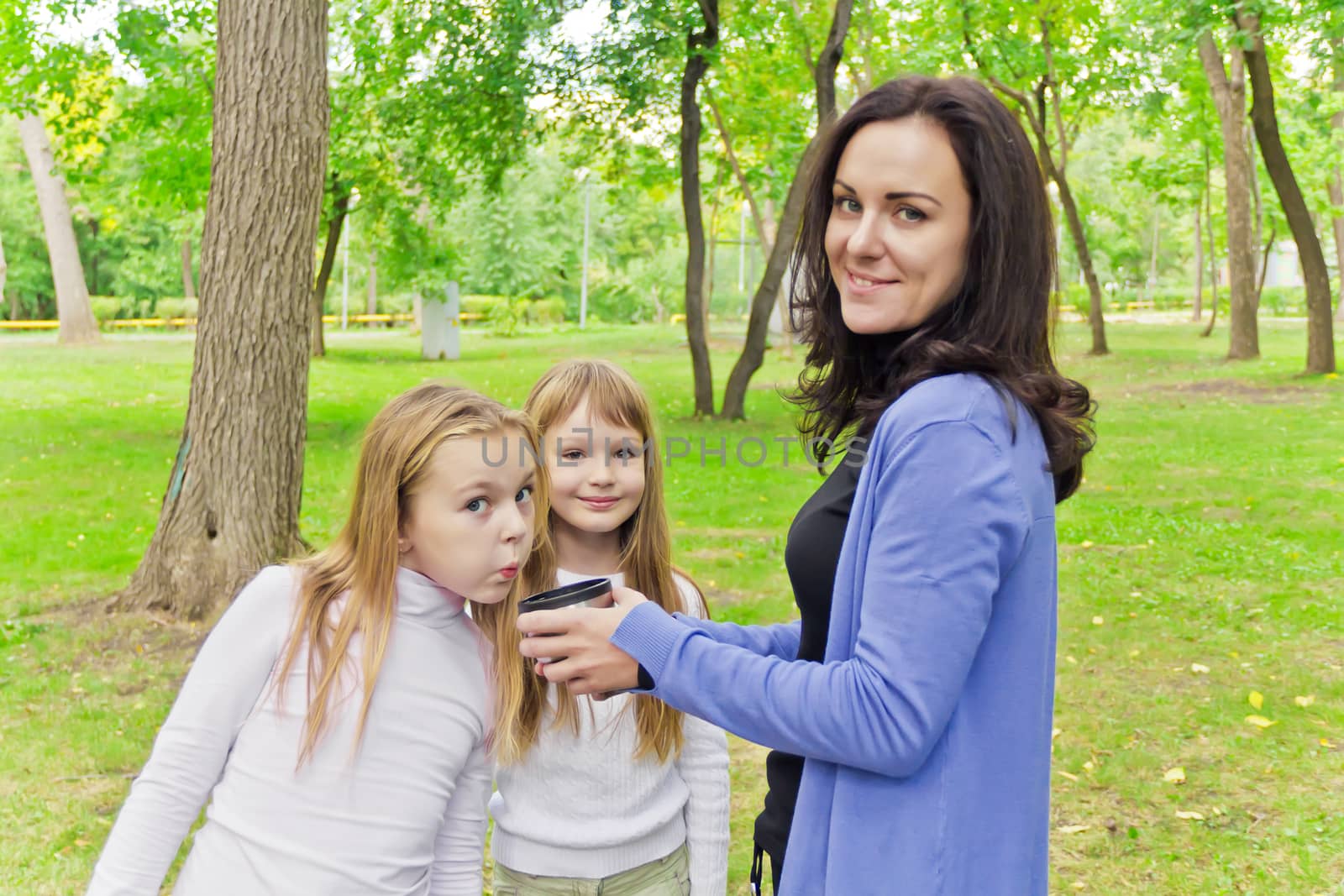 Photo of woman with two girls drinking tea
