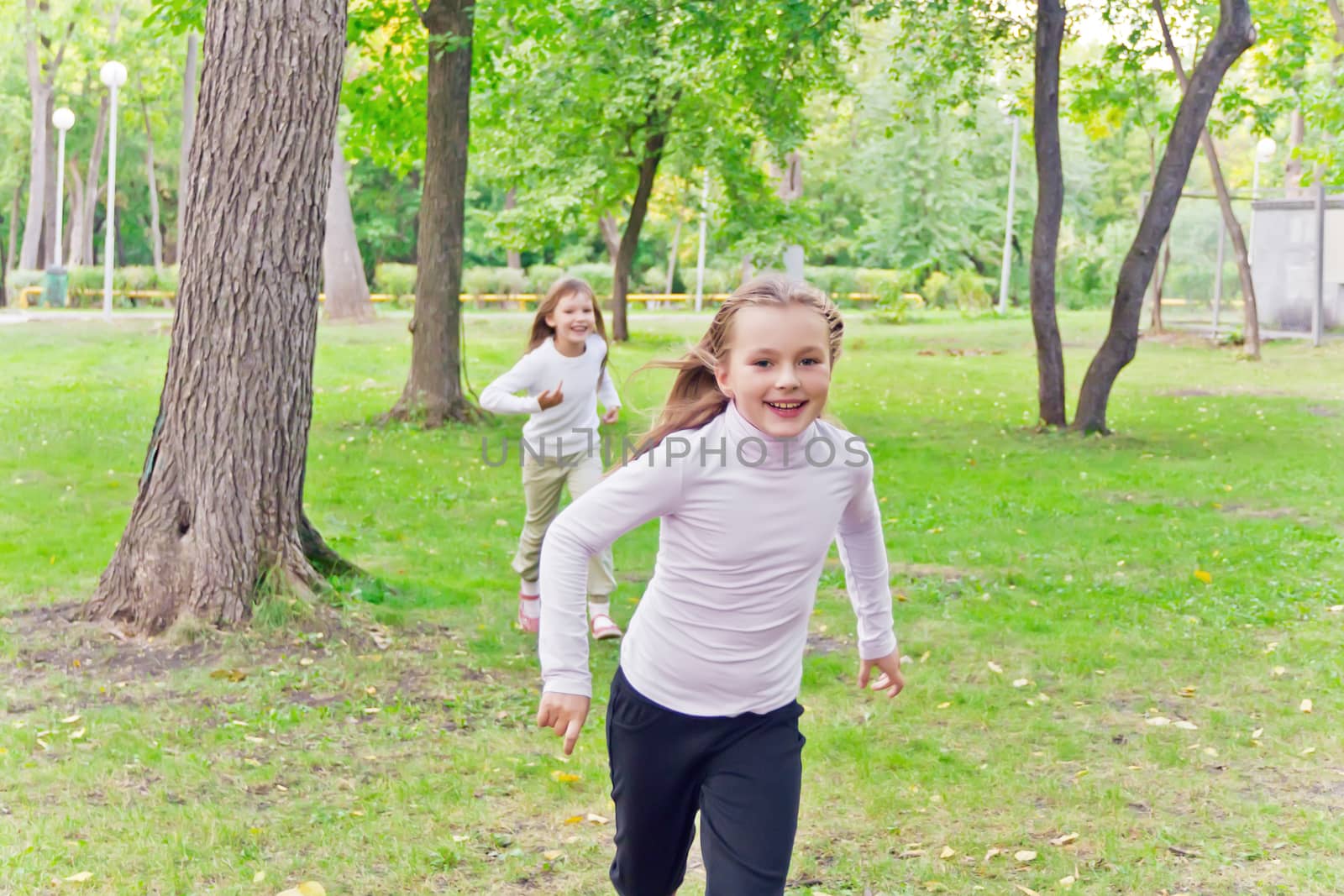 Photo of two running girls in summer