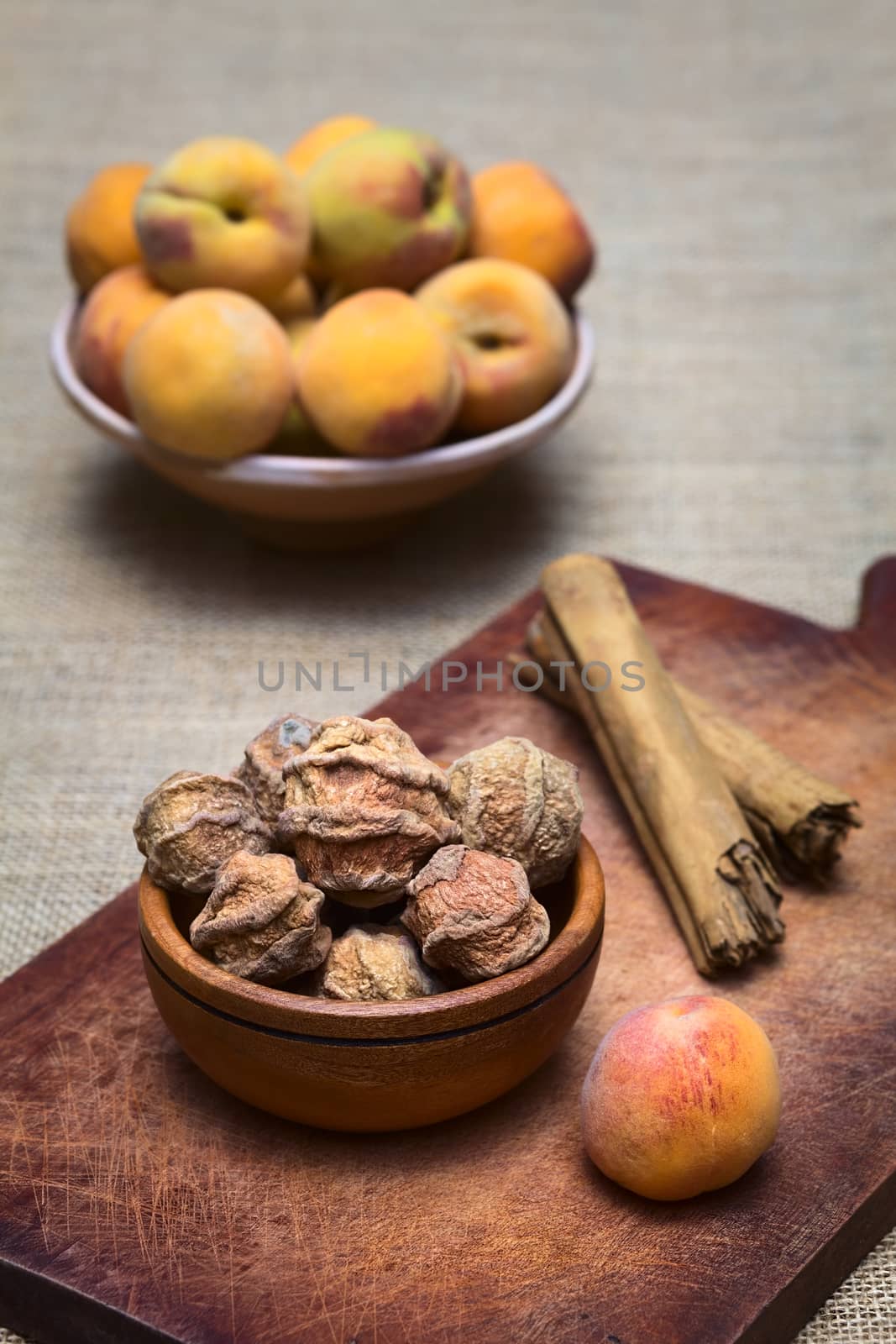 Dried peeled peach called quisa (also kisa, mocochinchi) from which a beverage is prepared with sugar and cinnamon in Bolivia. The drink is very popular and sold on the streets in Bolivia (Photographed with natural light) (Selective Focus, Focus on the front peaches)
 